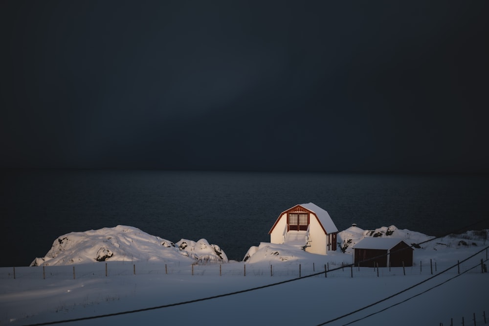 a barn in the middle of a snowy field