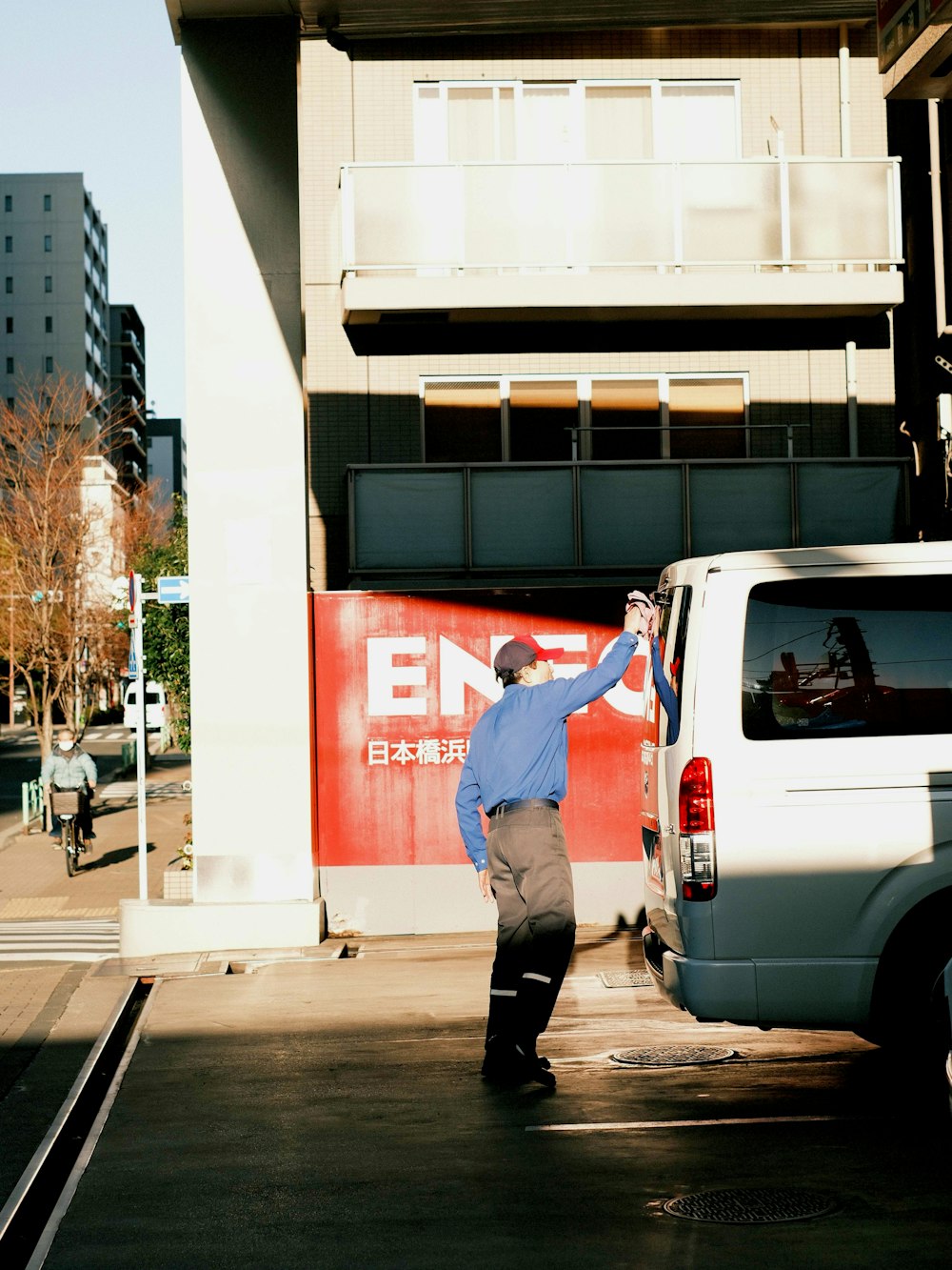 a man standing next to a white van in a parking lot