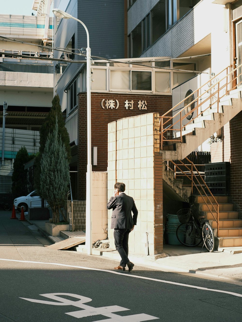 a man walking down a street next to a tall building
