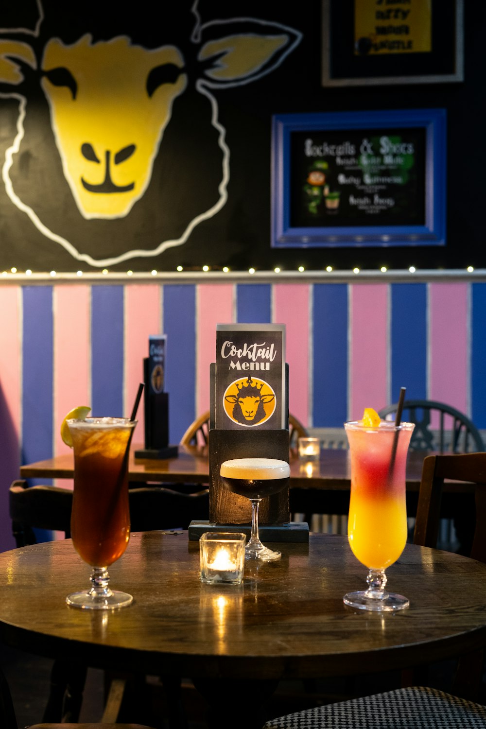 a table topped with two drinks next to a menu