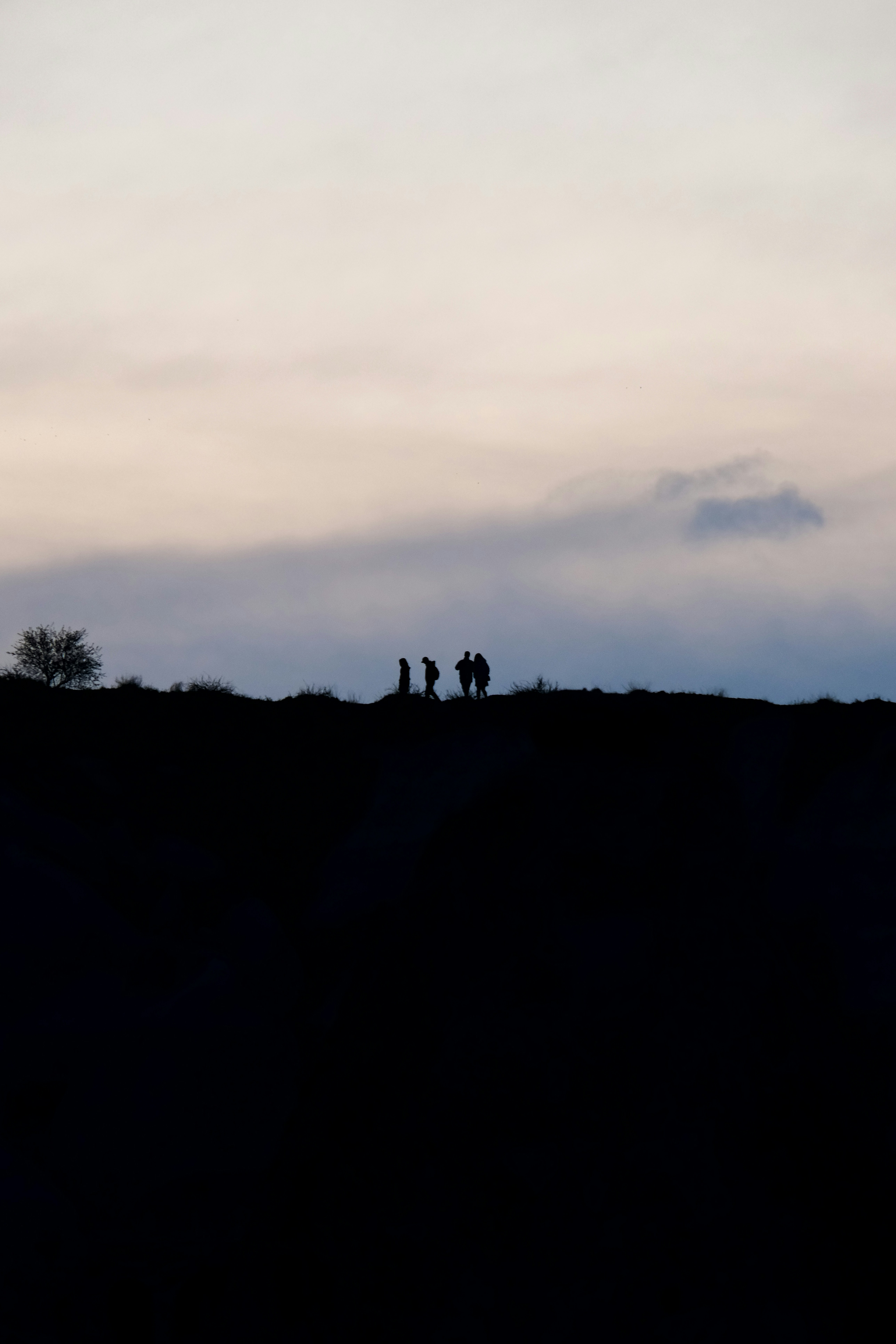 a group of people standing on top of a hill - a-group-of-people-standing-on-top-of-a-hill-XJ_i1X8Zras