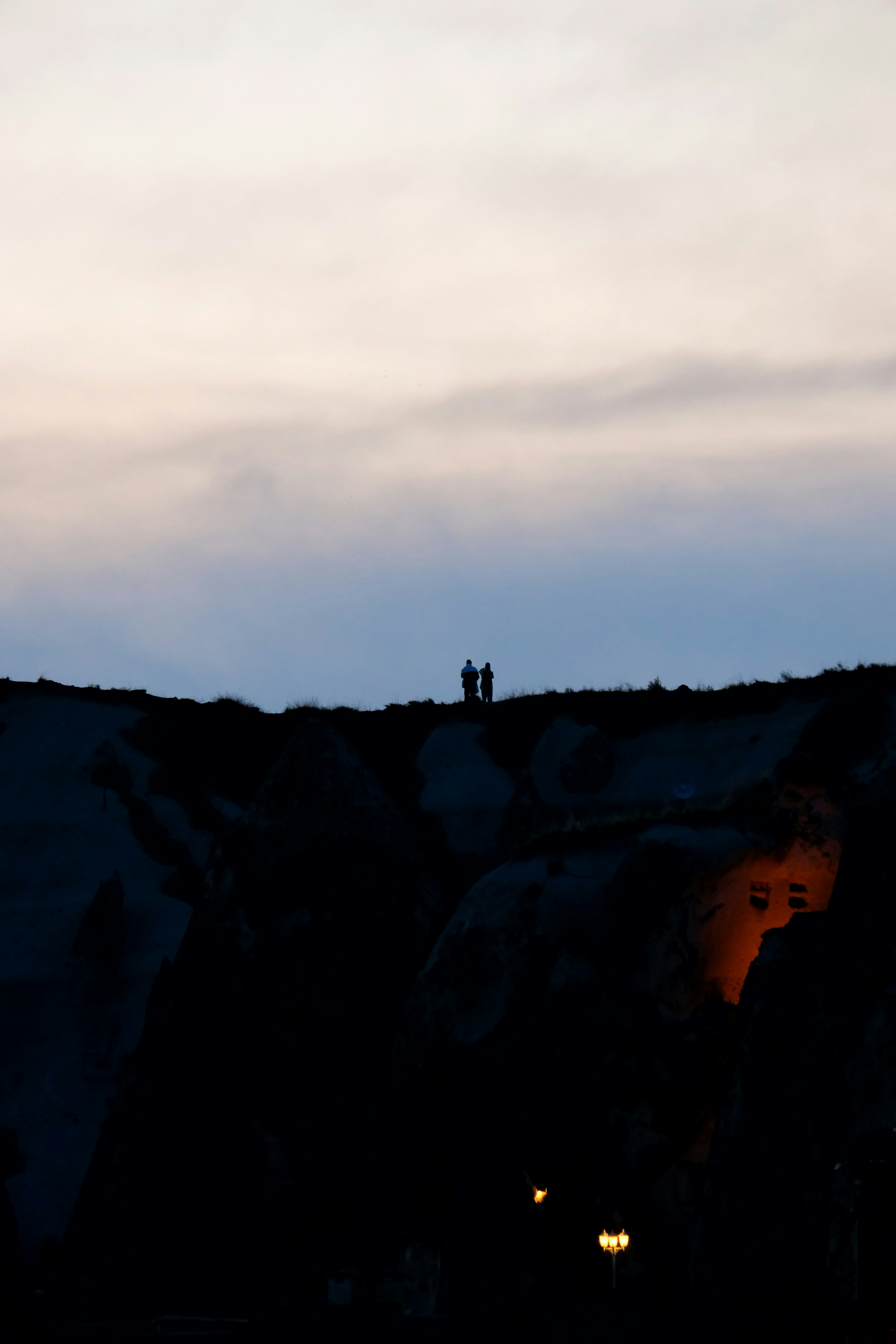 a couple of people standing on top of a hill - a-couple-of-people-standing-on-top-of-a-hill-avg5j6Xdu1s