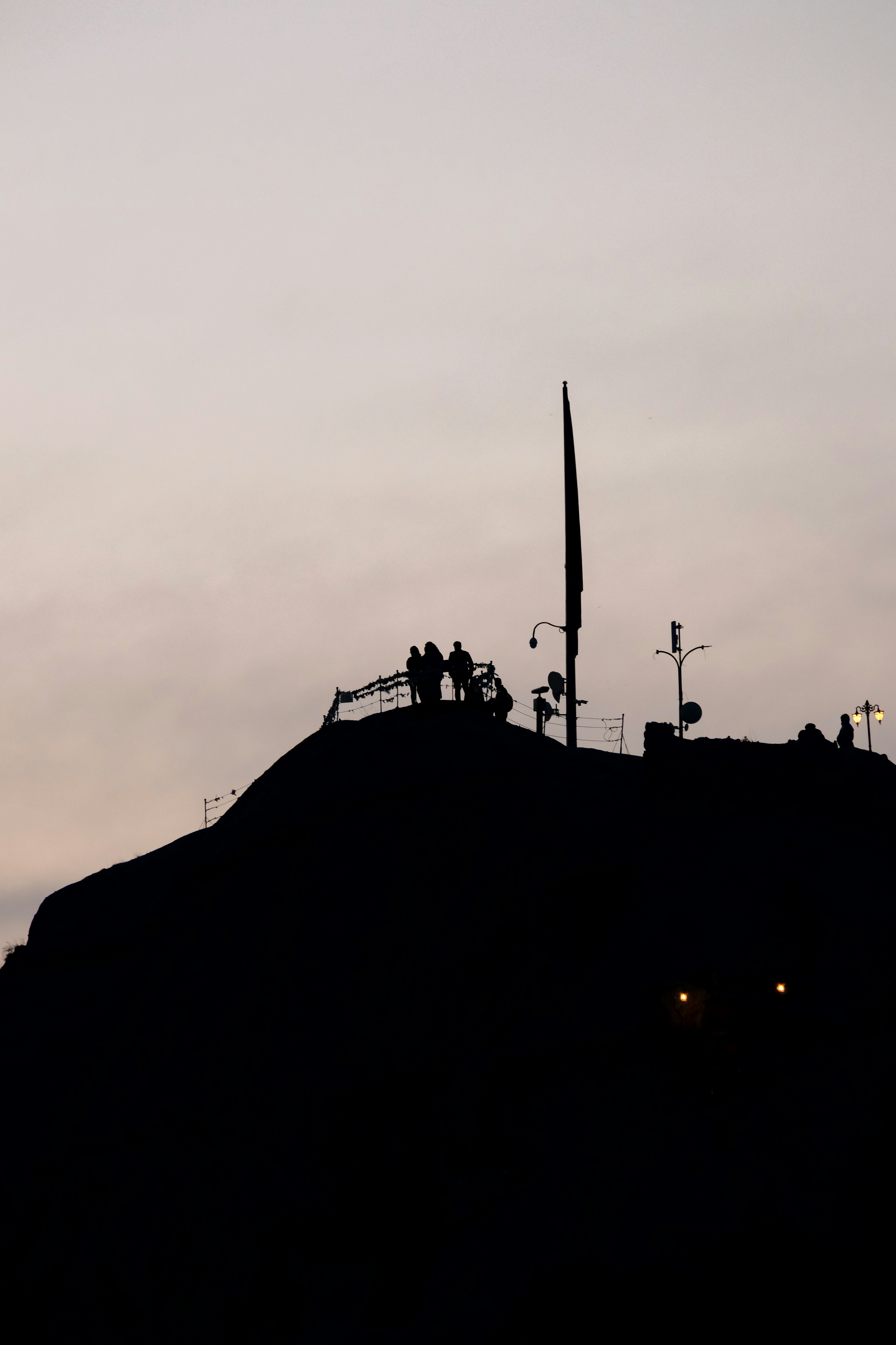 a hill with a clock tower on top of it - a-hill-with-a-clock-tower-on-top-of-it-MkTiUPu4PDU