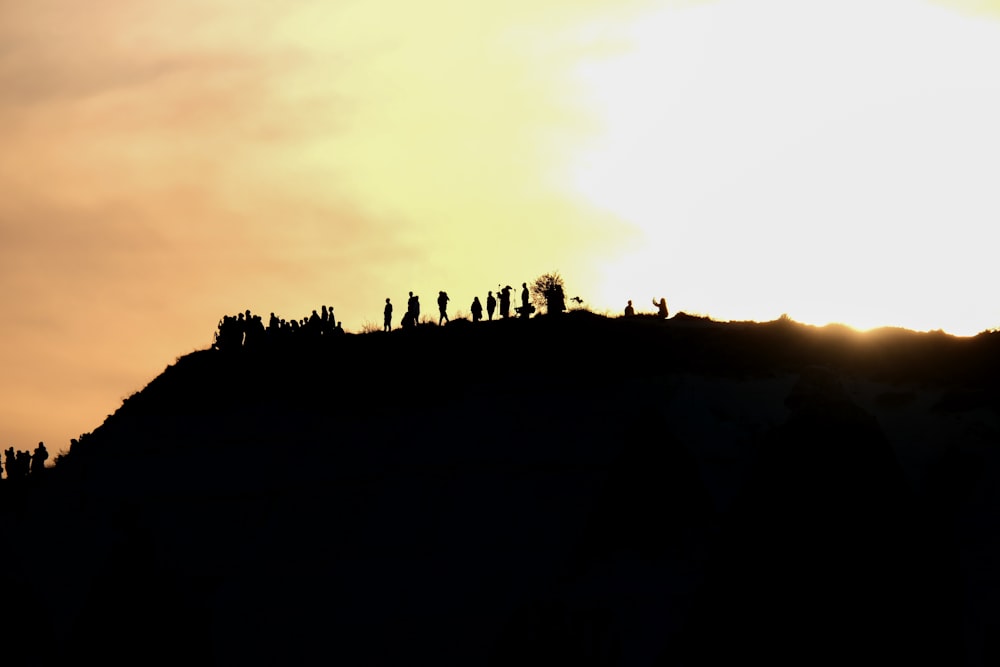 Un grupo de personas de pie en la cima de una colina