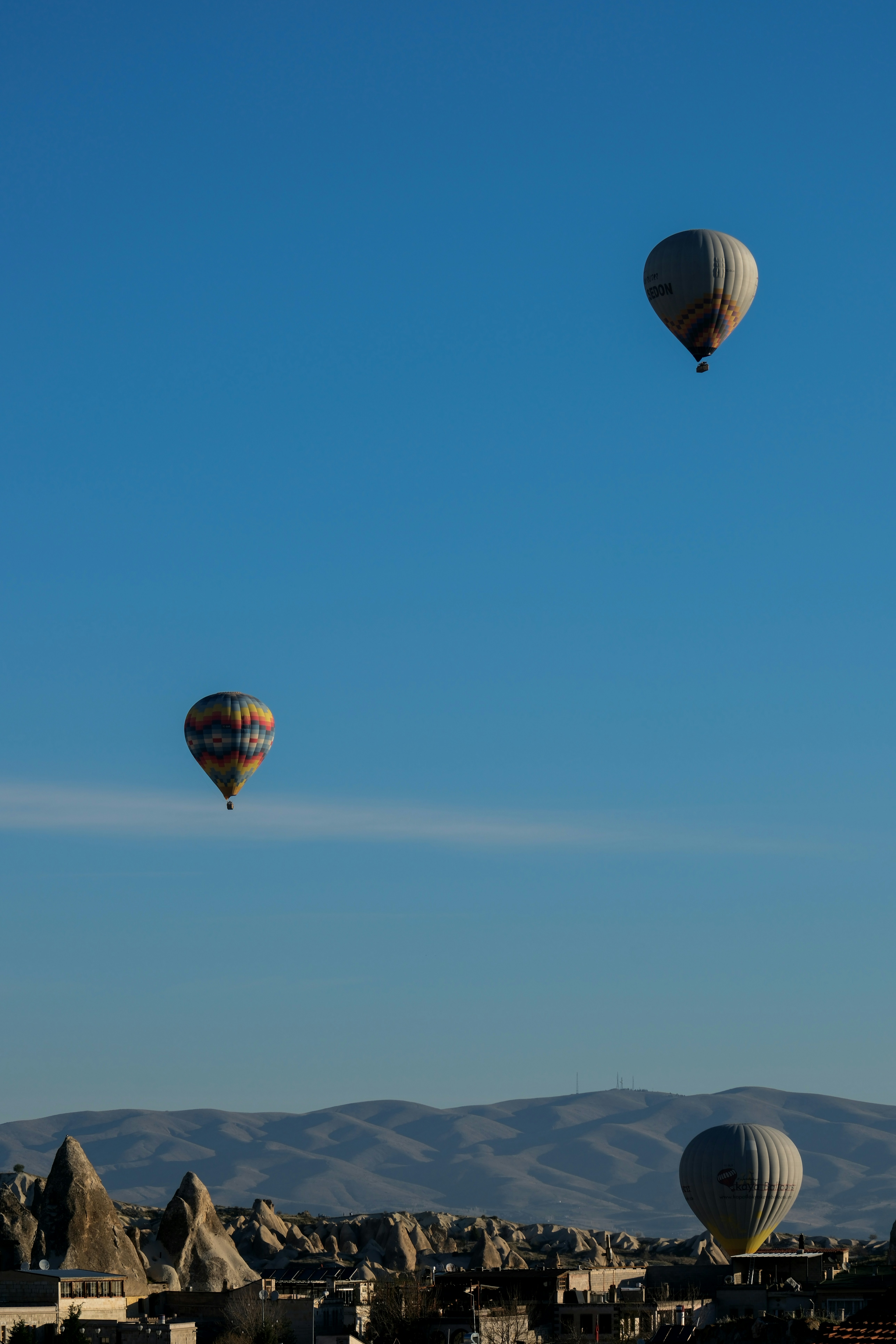 three hot air balloons flying in the sky - three-hot-air-balloons-flying-in-the-sky-WLB58qn9UuQ