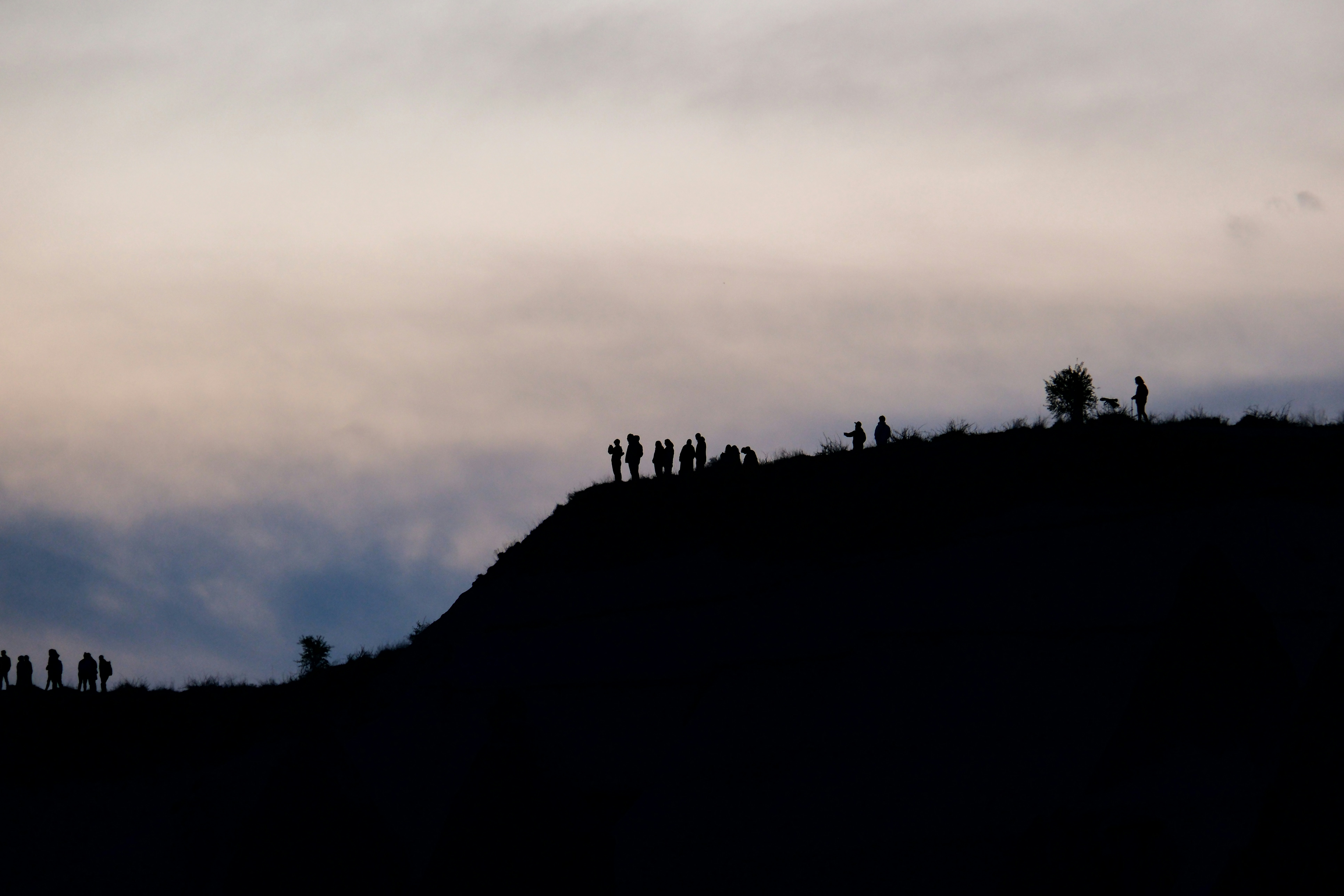 a group of people standing on top of a hill, 