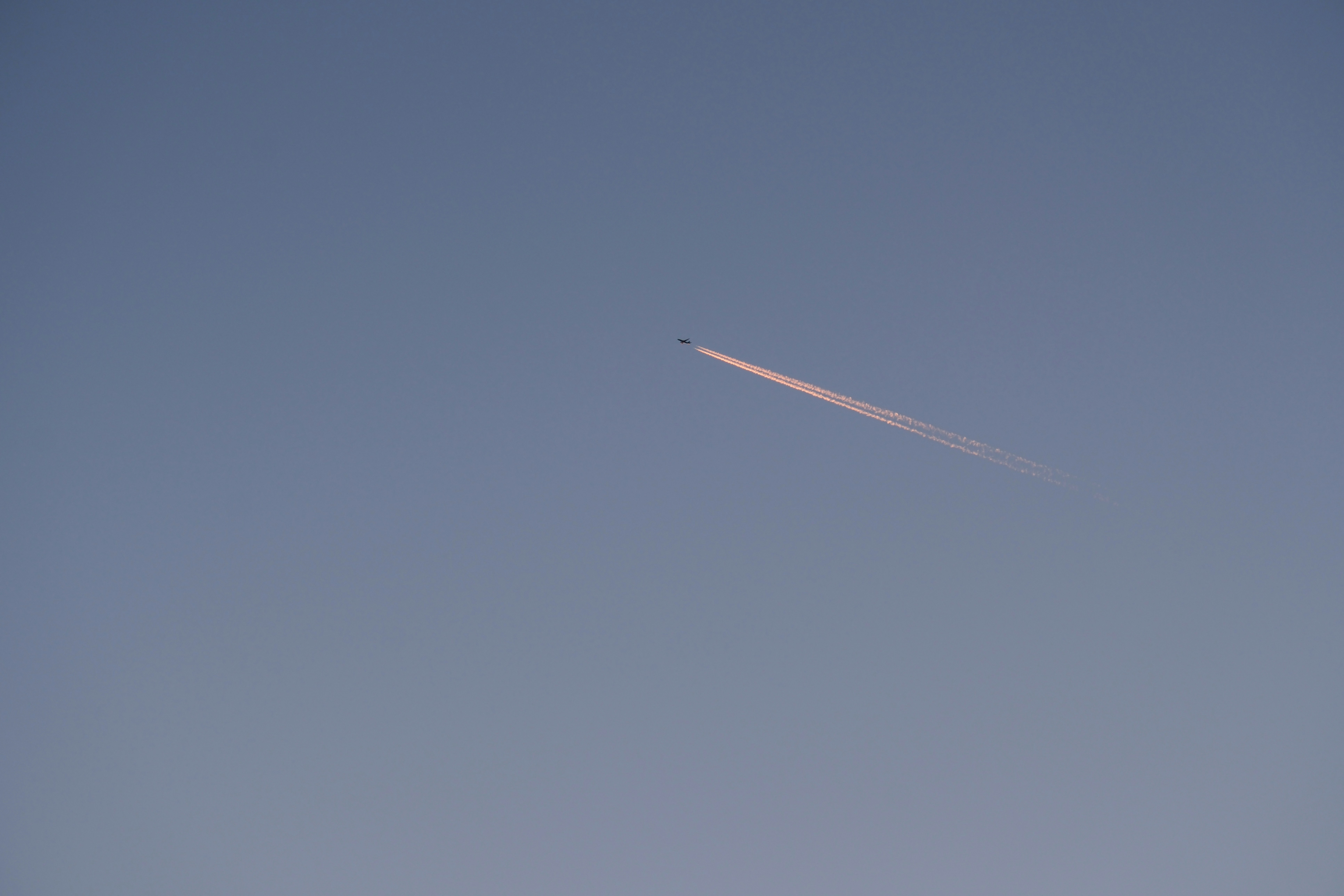 an airplane flying in the sky with a contrail - an-airplane-flying-in-the-sky-with-a-contrail-e9FBGeMSEAs