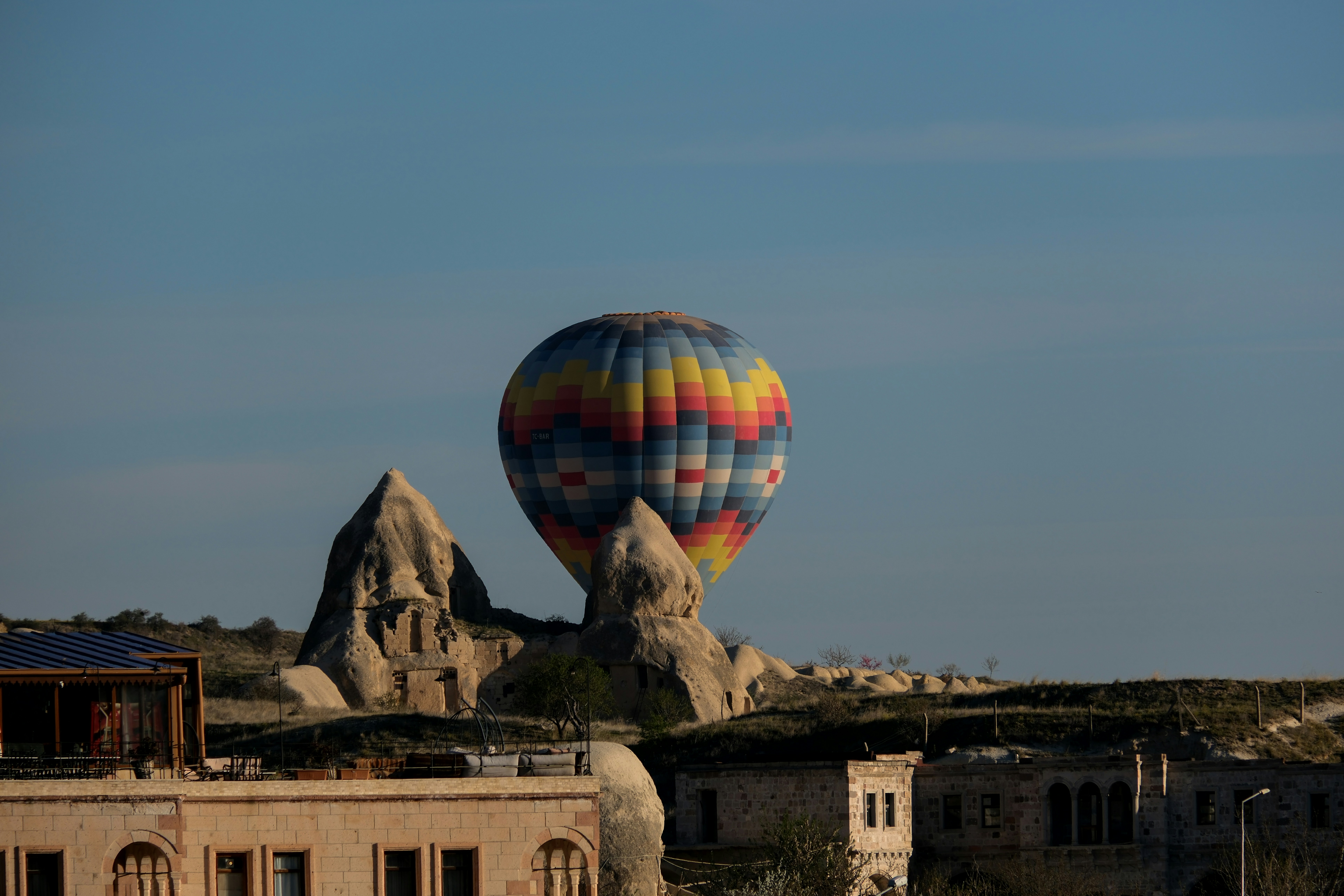a hot air balloon flying over a desert landscape - a-hot-air-balloon-flying-over-a-desert-landscape-ps4LiY_BA2A