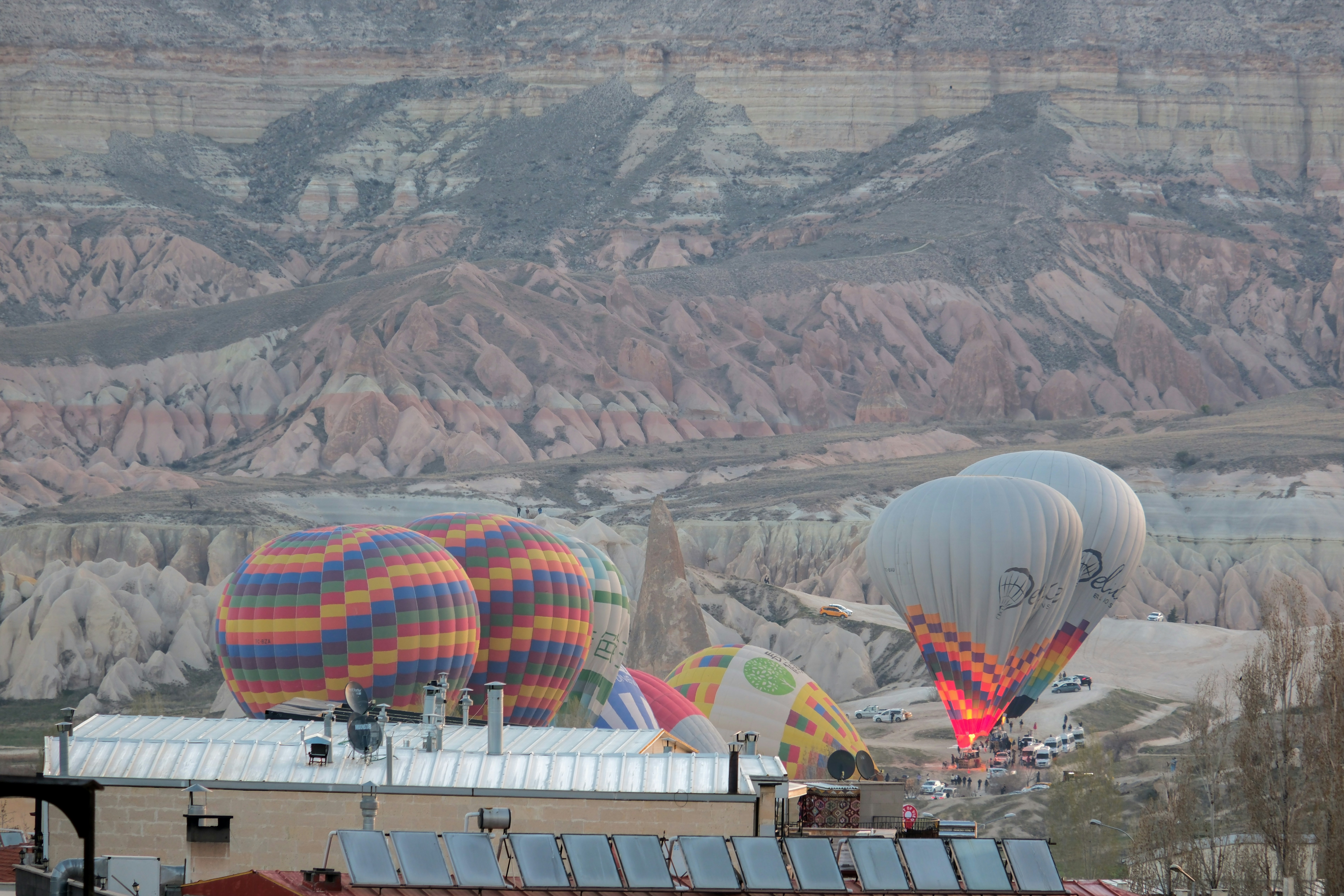 a group of hot air balloons flying over a mountain - a-group-of-hot-air-balloons-flying-over-a-mountain-6r6qDtOc8aI