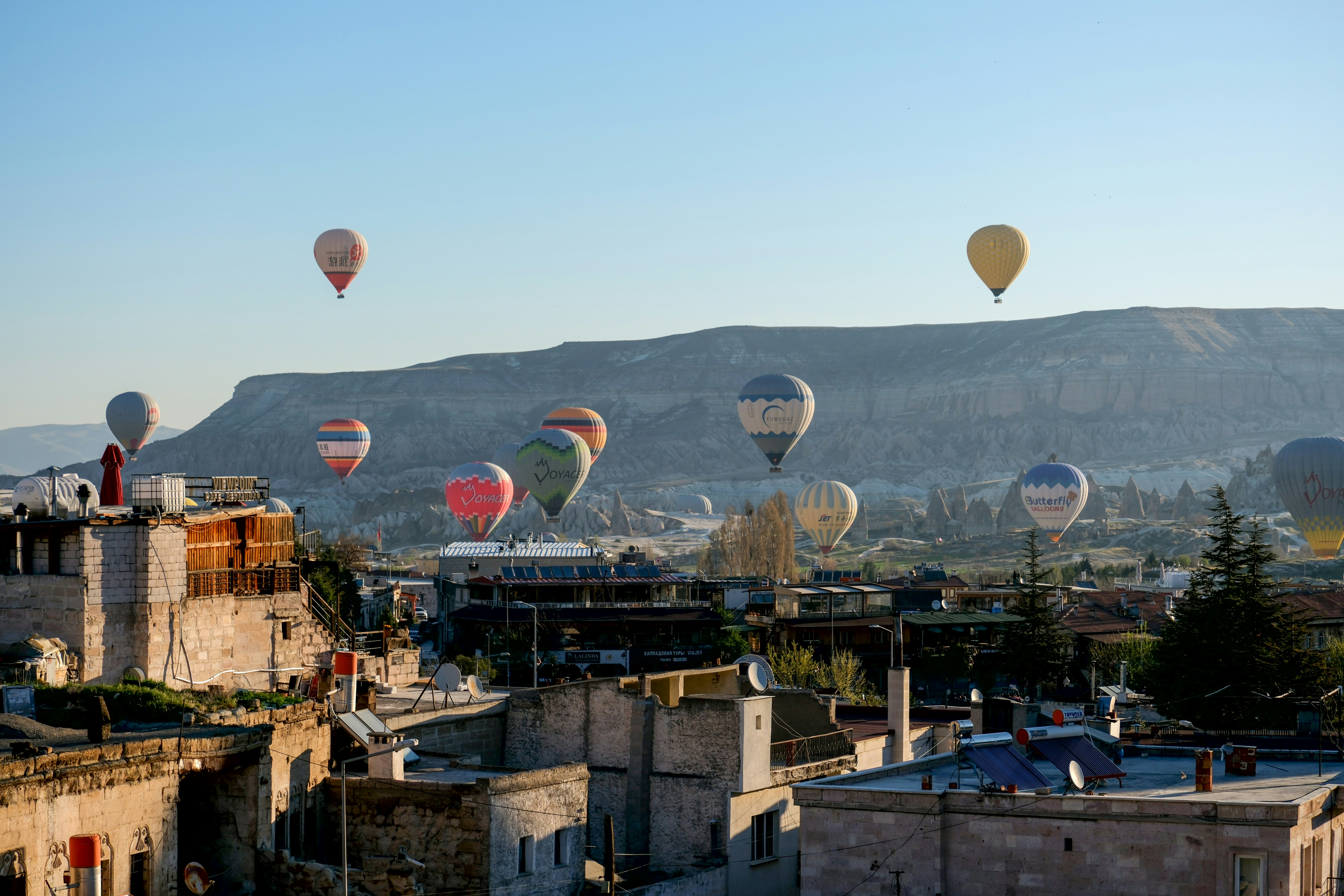 a group of hot air balloons flying over a city - a-group-of-hot-air-balloons-flying-over-a-city-N_nGrKJHmKY