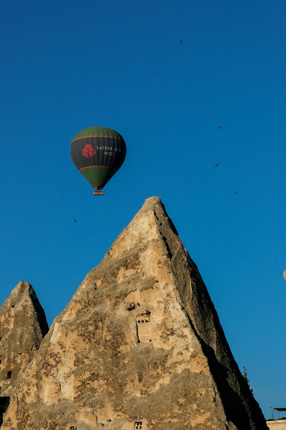a hot air balloon flying over a rock formation