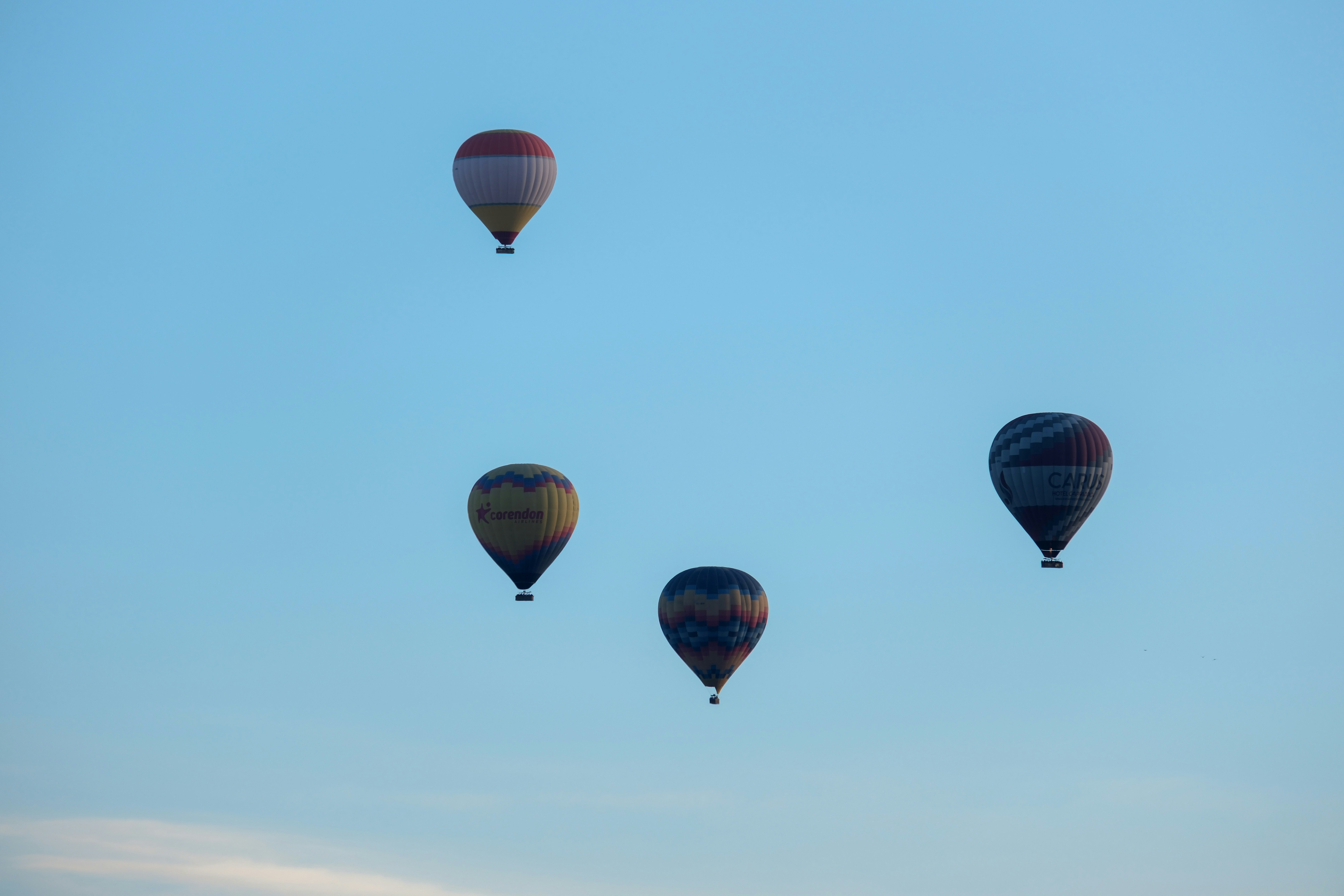 a group of hot air balloons flying in the sky - a-group-of-hot-air-balloons-flying-in-the-sky-kC_LpUG-OdU