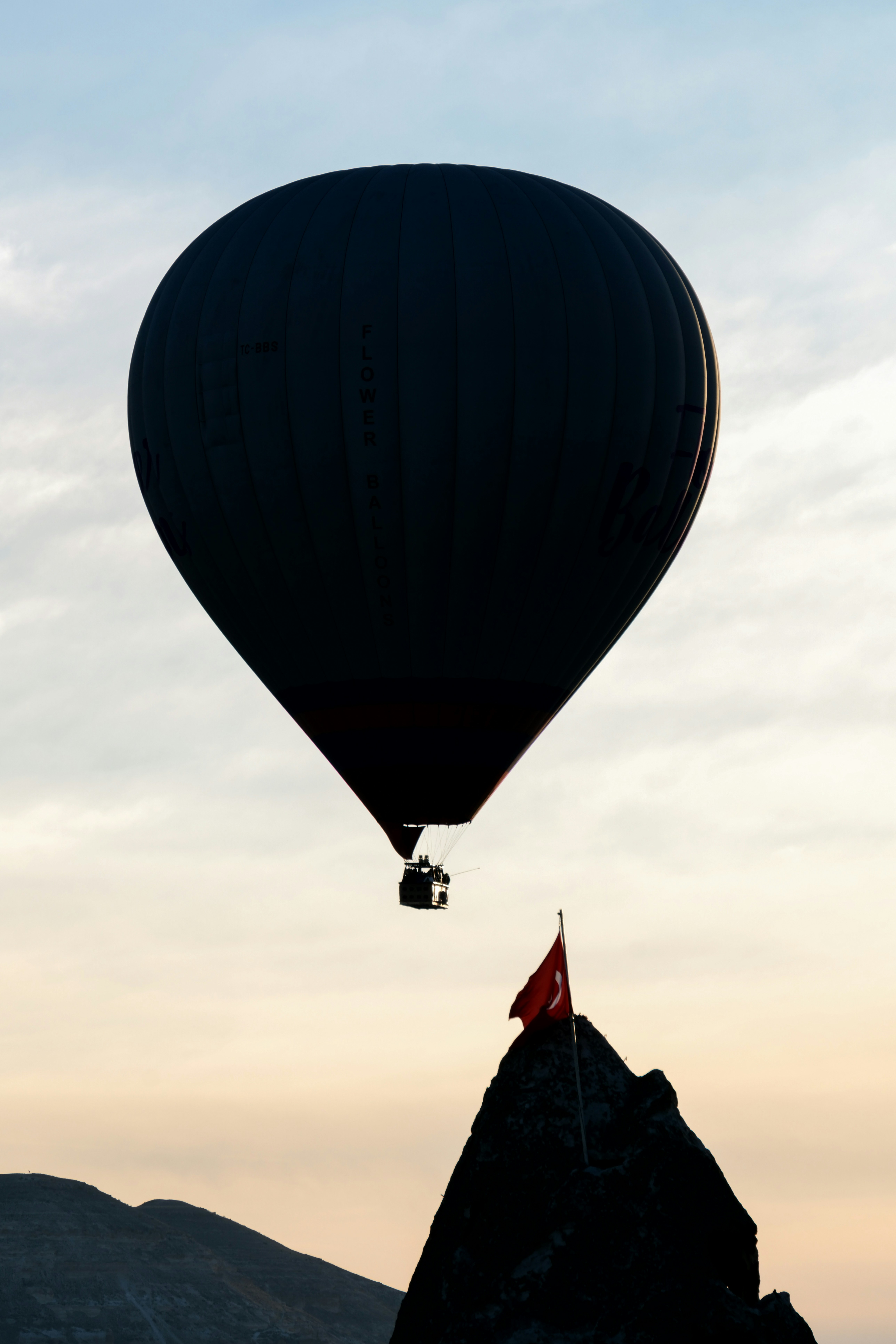a hot air balloon flying over a mountain - a-hot-air-balloon-flying-over-a-mountain-vAq7FyCgeT4