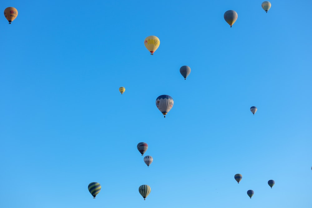 un grupo de globos aerostáticos volando a través de un cielo azul