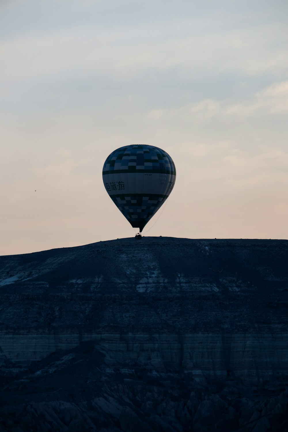 a hot air balloon flying over a mountain