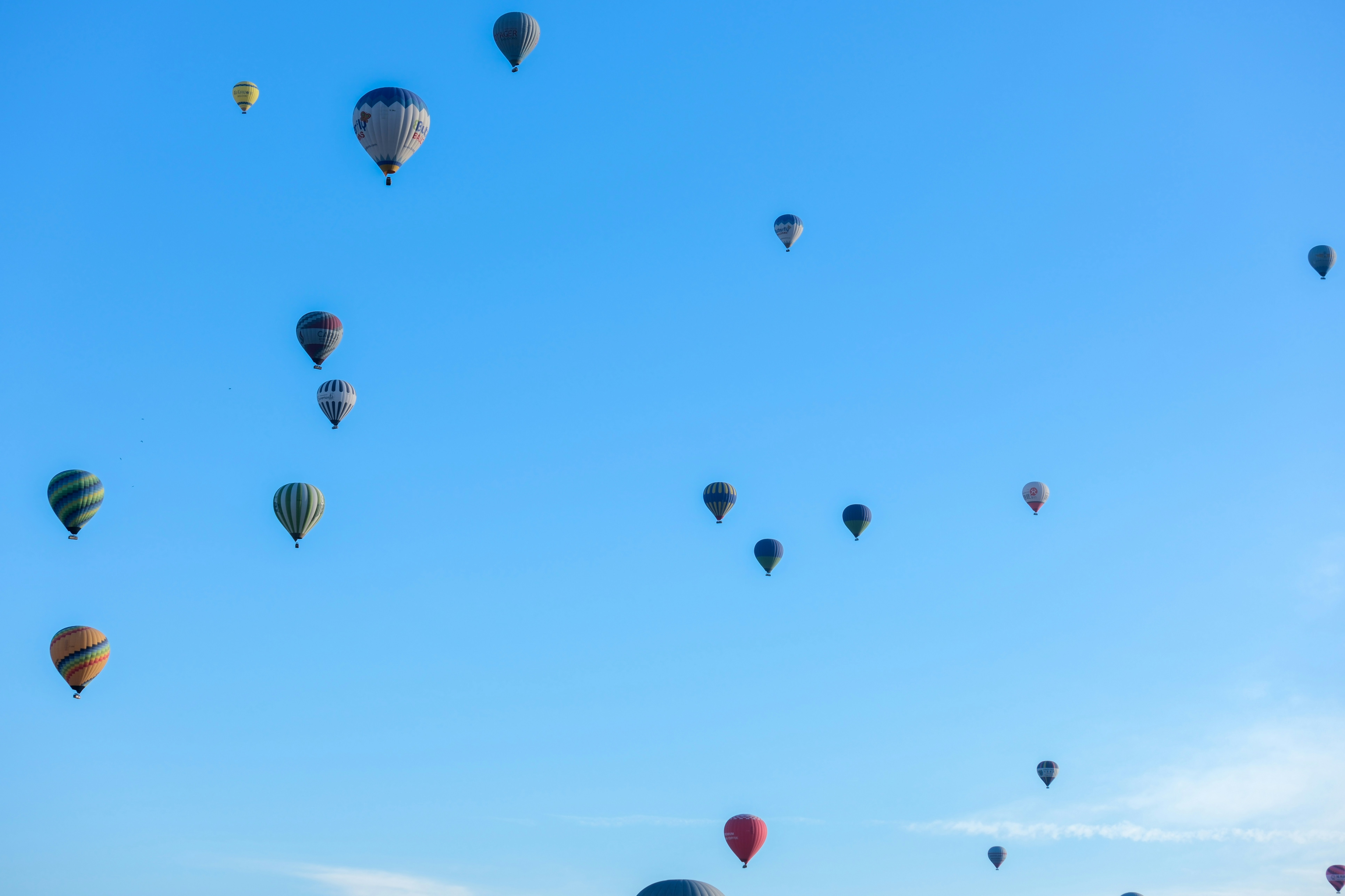 a bunch of hot air balloons flying in the sky - a-bunch-of-hot-air-balloons-flying-in-the-sky-EXEwQIutpLA
