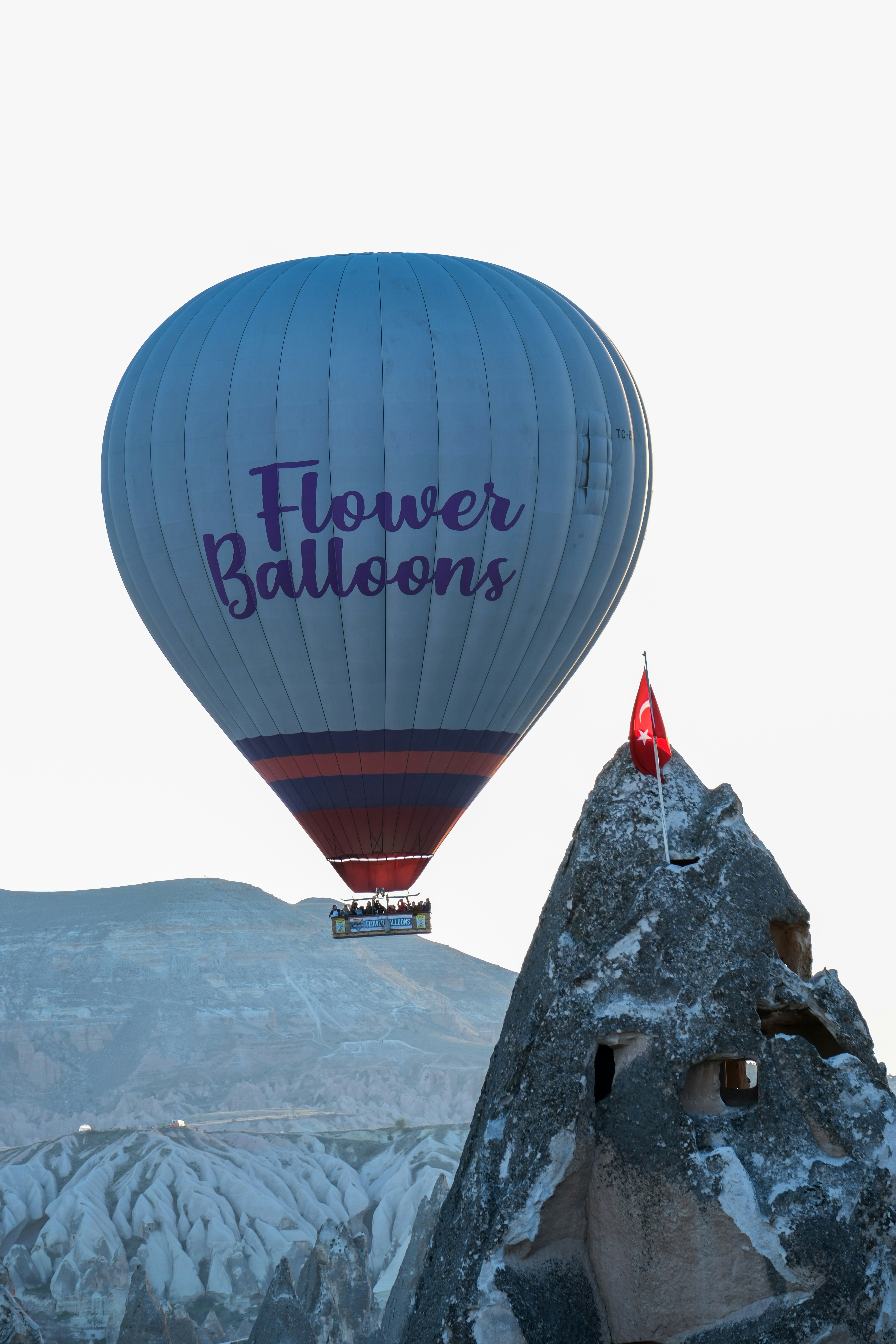 a hot air balloon flying over a mountain - a-hot-air-balloon-flying-over-a-mountain-bv4Wg0ZjtEY