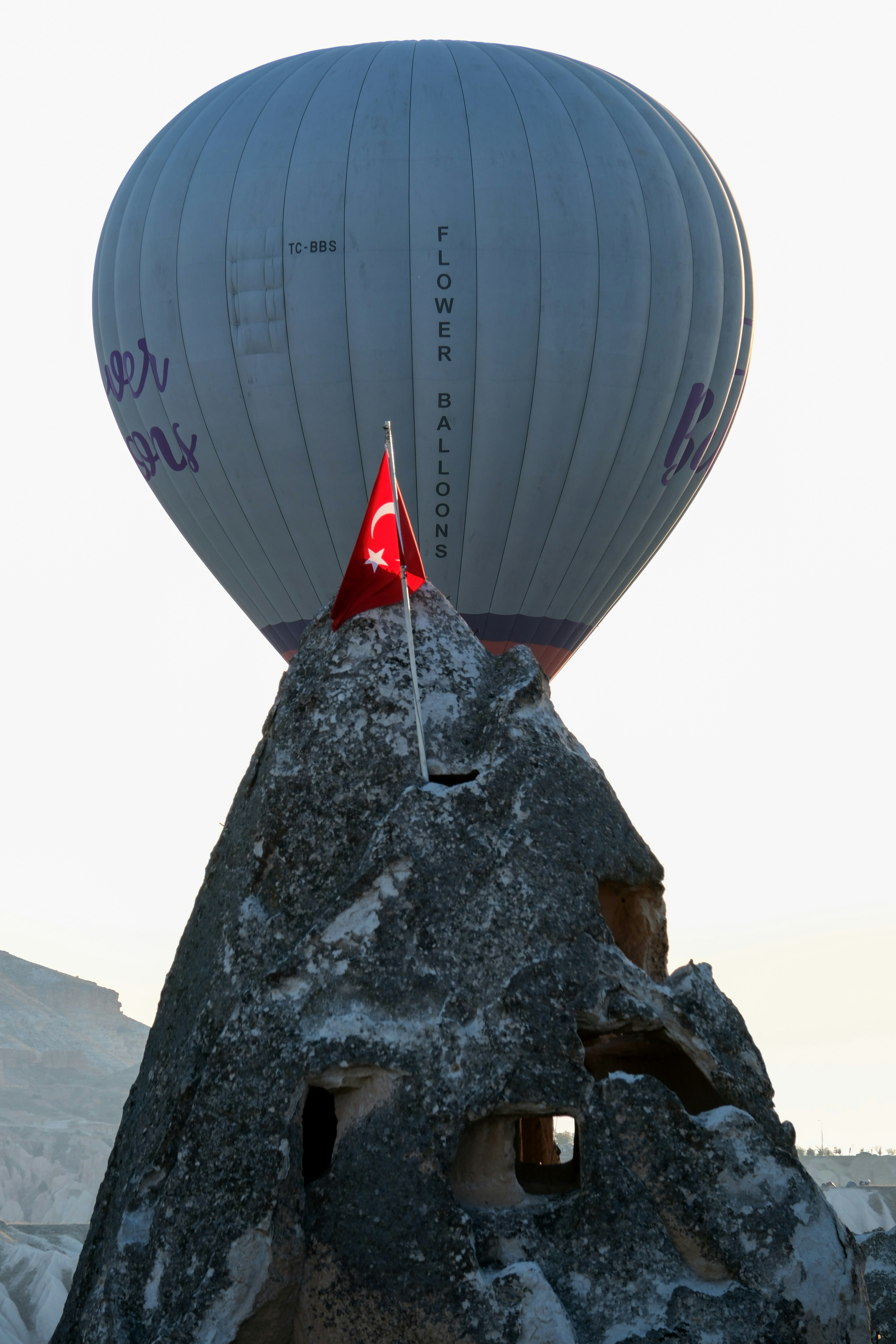 a large hot air balloon sitting on top of a rock - a-large-hot-air-balloon-sitting-on-top-of-a-rock-Xlgq0AtHKiE