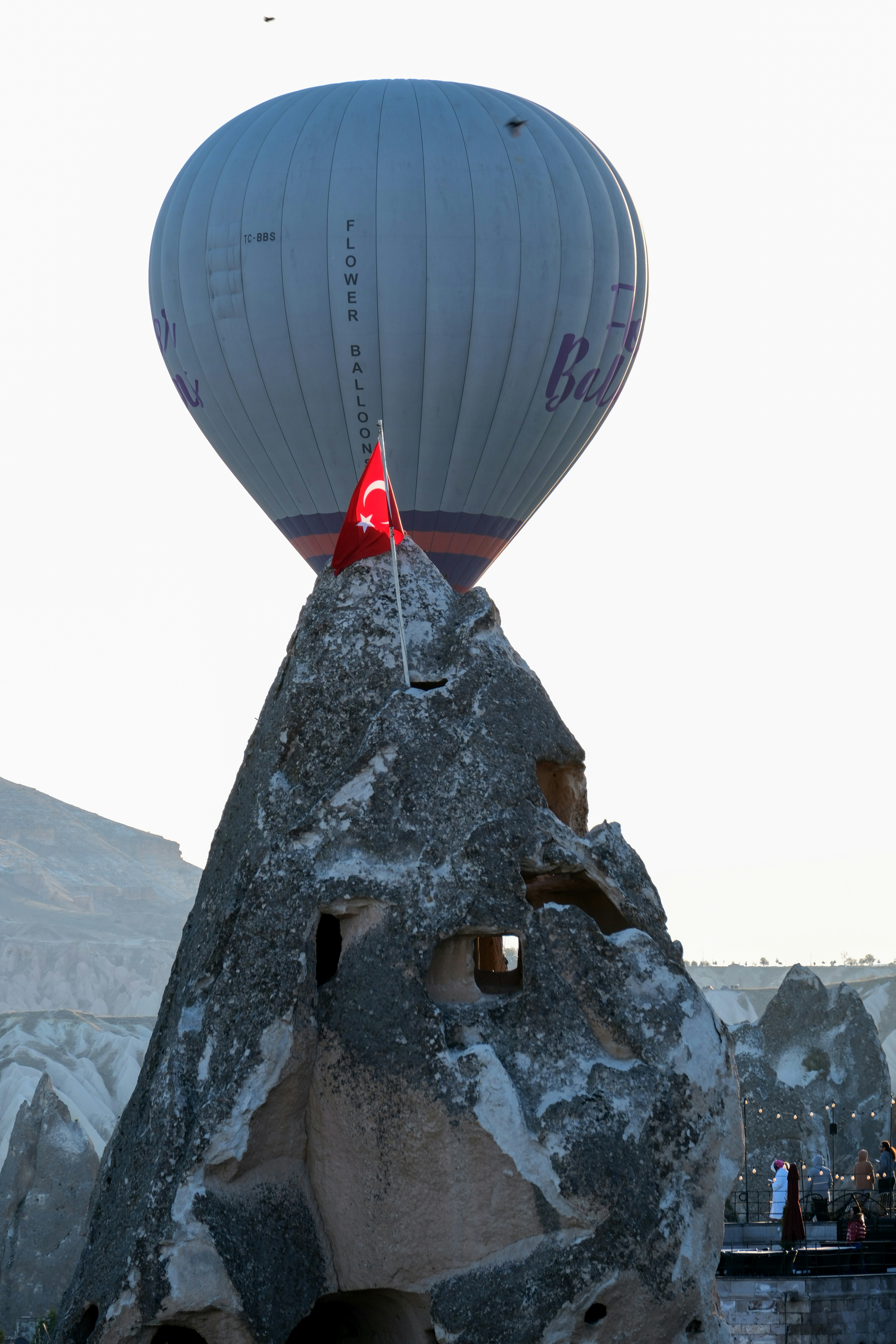 a large hot air balloon flying over a mountain - a-large-hot-air-balloon-flying-over-a-mountain-xk9cXYsCLwY