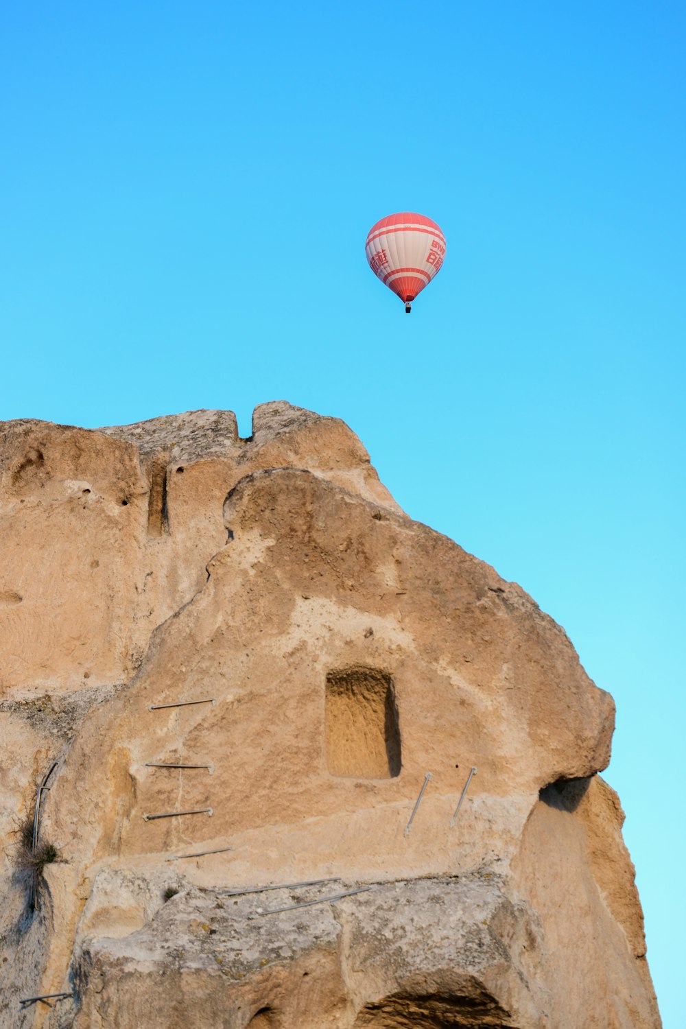 a hot air balloon flying over a rock formation