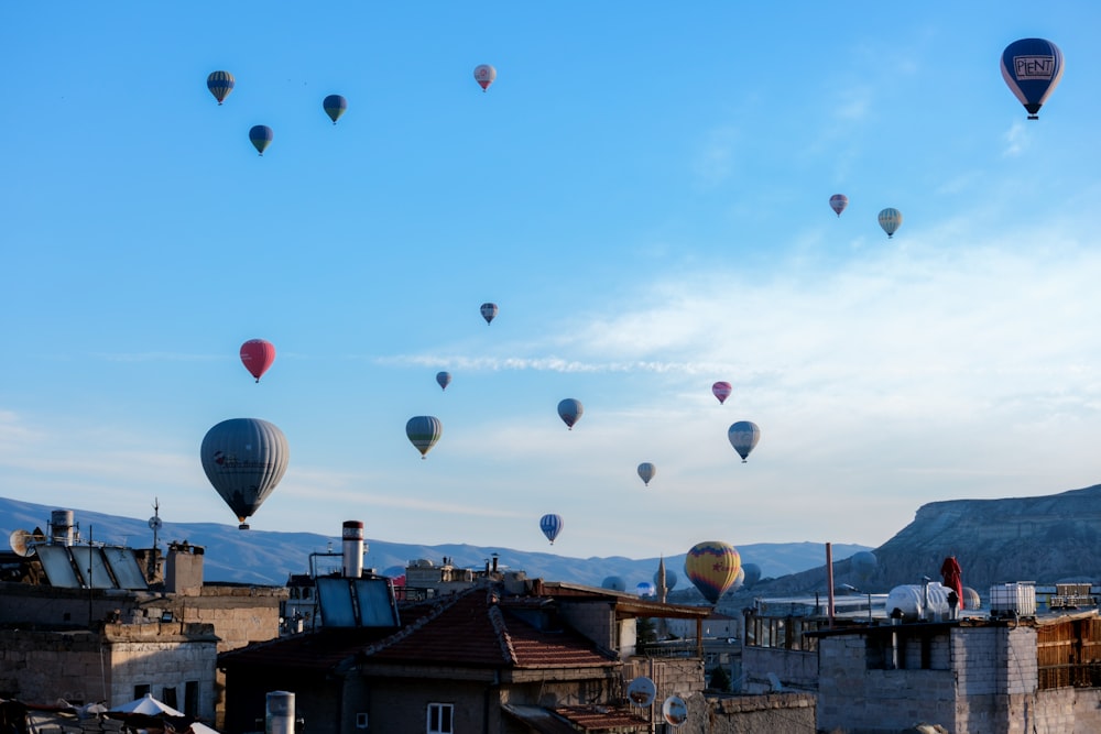 a group of hot air balloons flying over a city