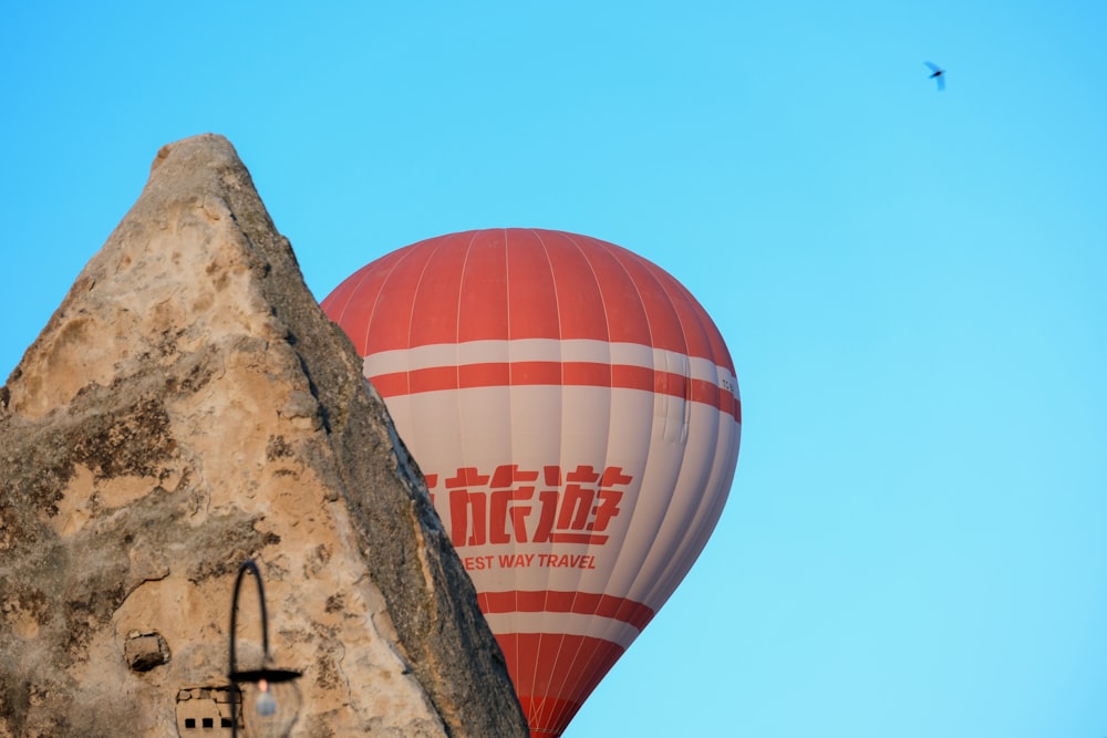 a hot air balloon flying over a stone wall