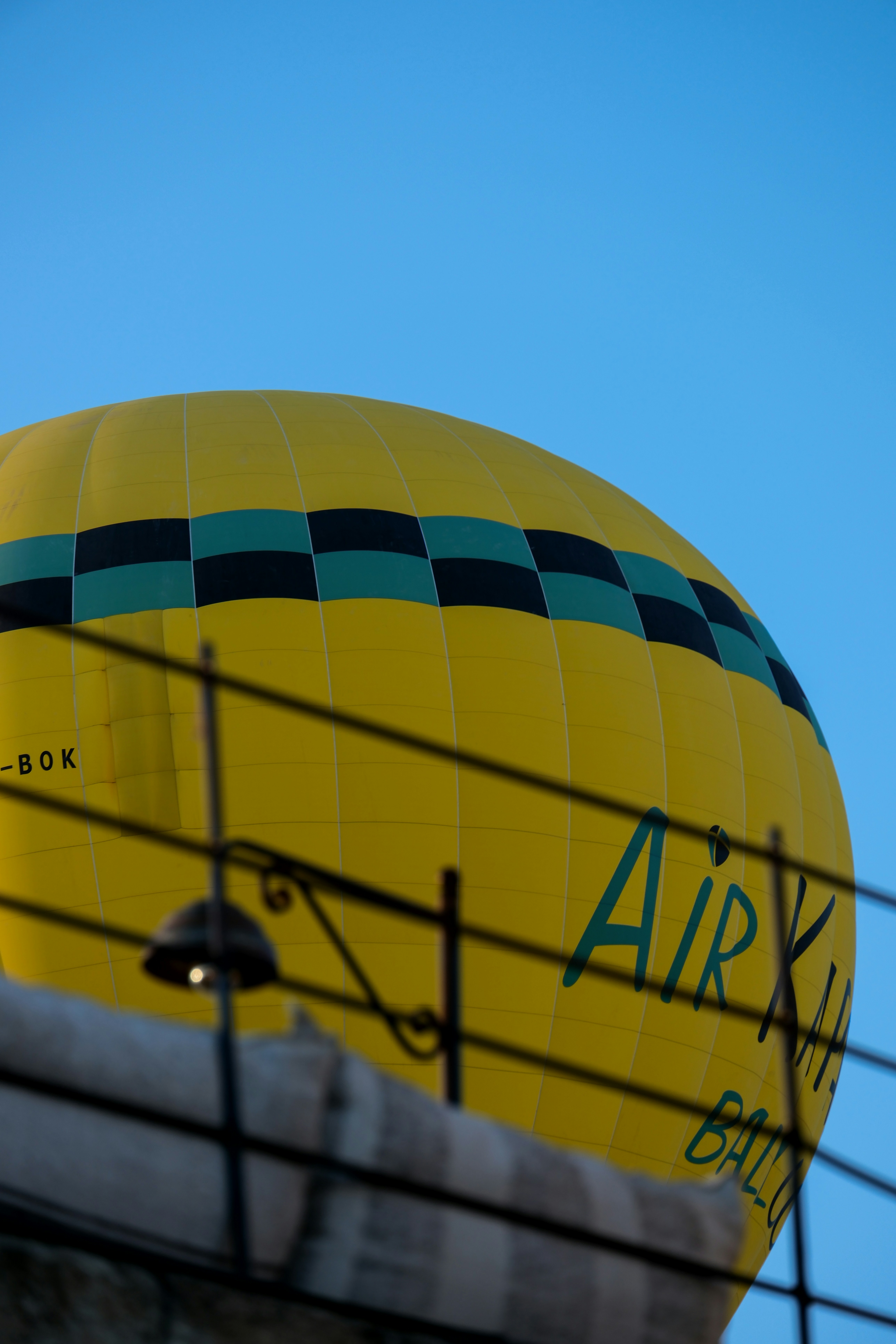 a large yellow hot air balloon sitting on top of a building - a-large-yellow-hot-air-balloon-sitting-on-top-of-a-building-fxyLyZ11vT0