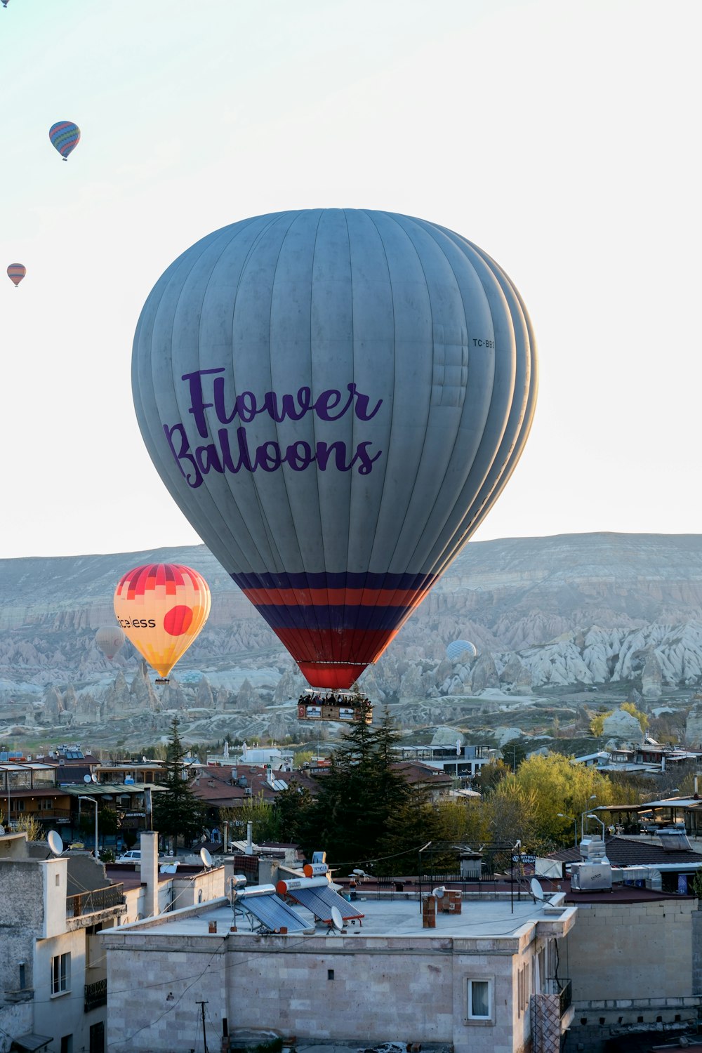 two hot air balloons flying over a city