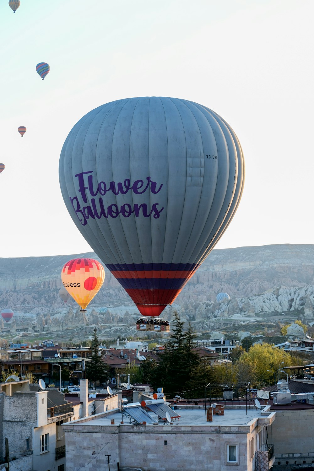 two hot air balloons flying over a city