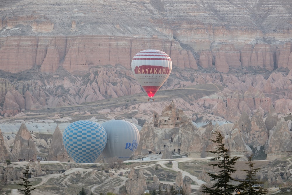a couple of hot air balloons flying over a valley