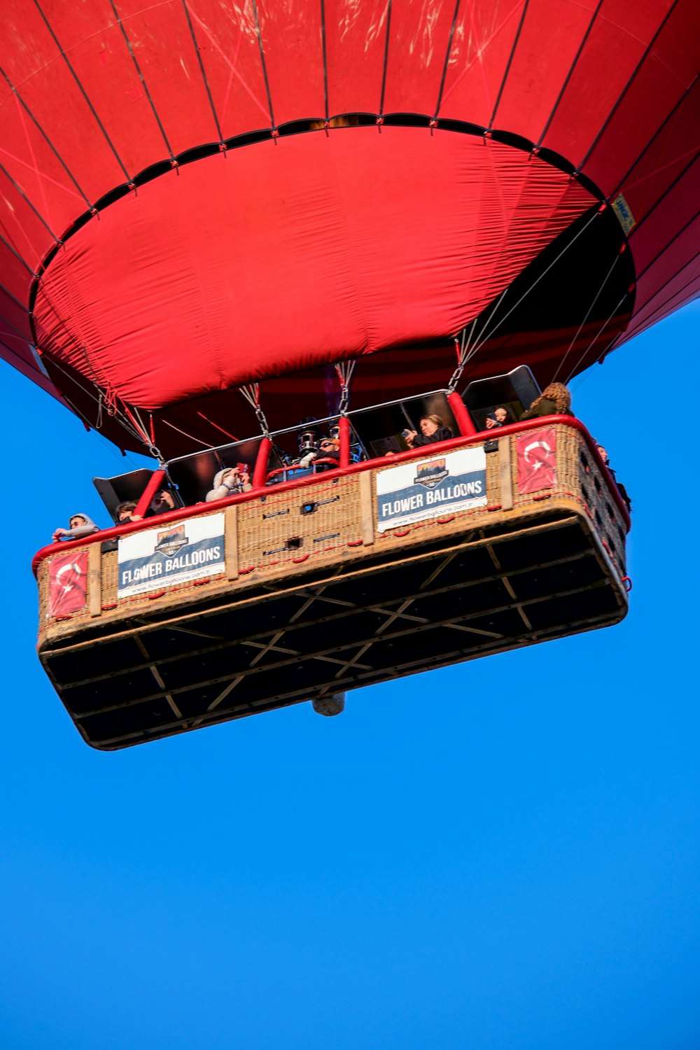 a red hot air balloon flying through a blue sky