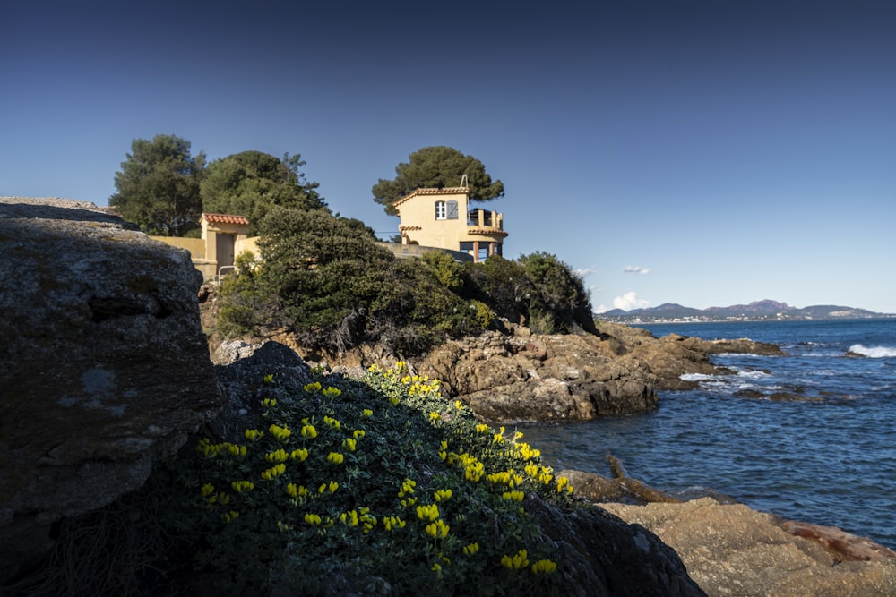 a house sitting on top of a cliff next to the ocean