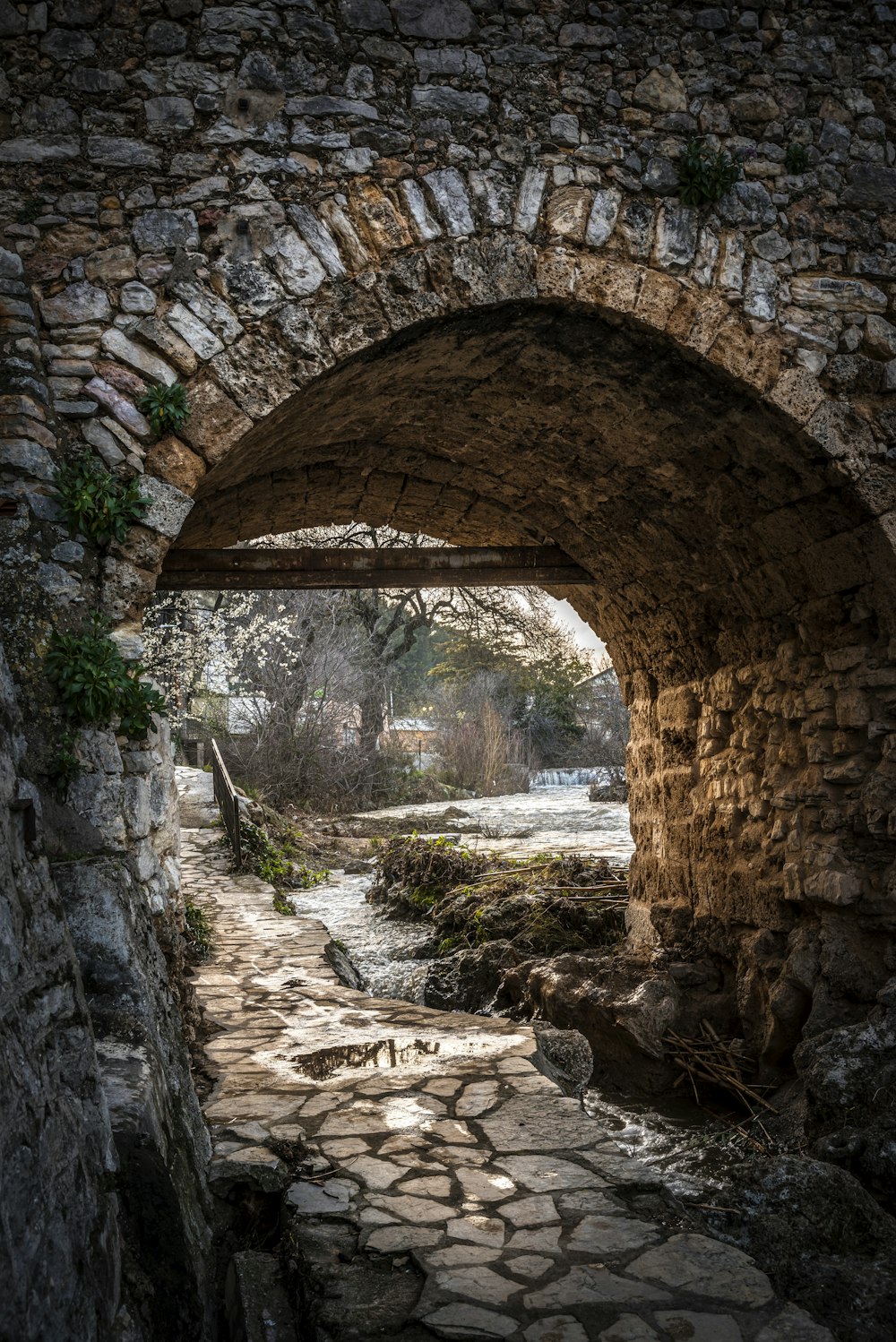 a stone tunnel with a stone walkway going through it