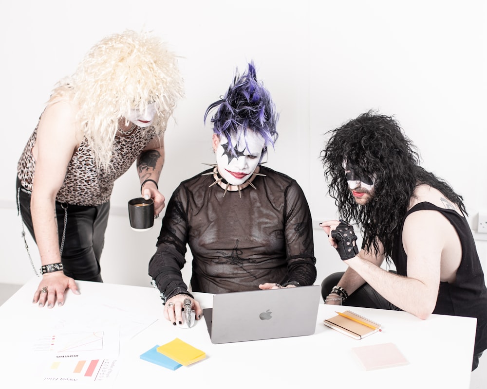 a couple of people sitting at a table with a laptop