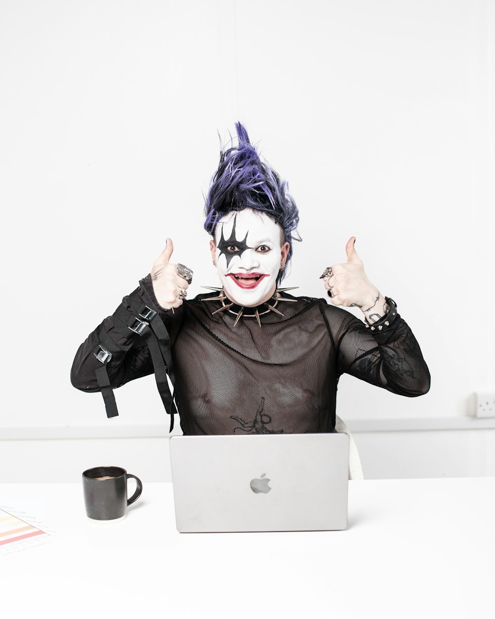 a person dressed as a joker with a laptop