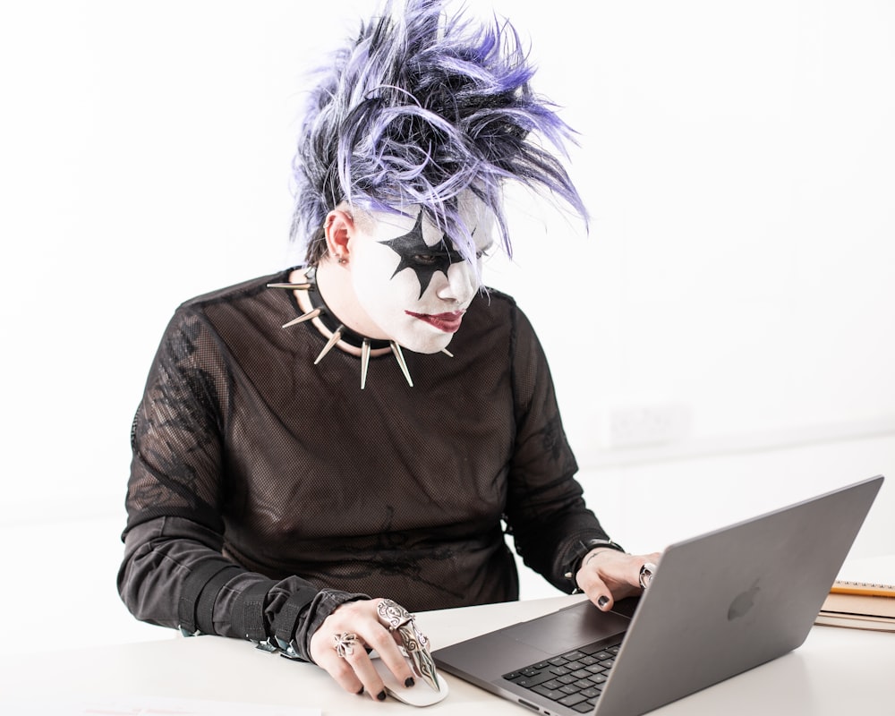 a person in a mask using a laptop