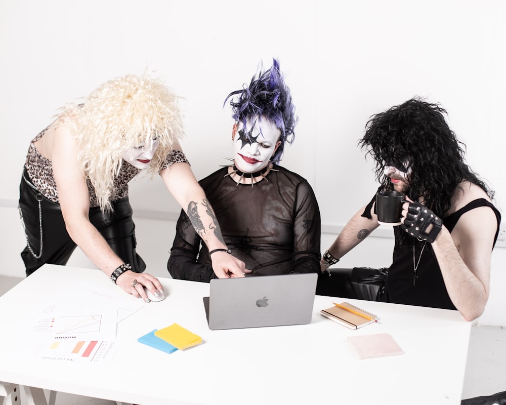 a couple of people sitting at a table with a laptop