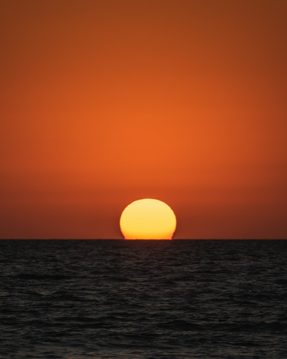 the sun is setting over the ocean on a clear day