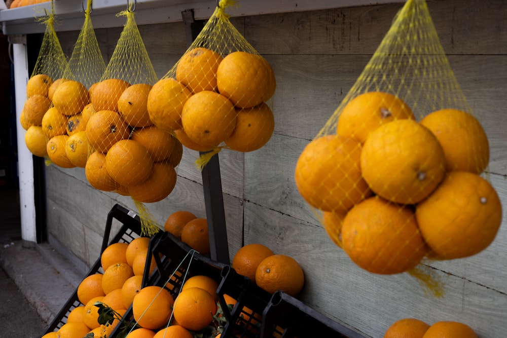 um monte de laranjas que estão penduradas em uma parede