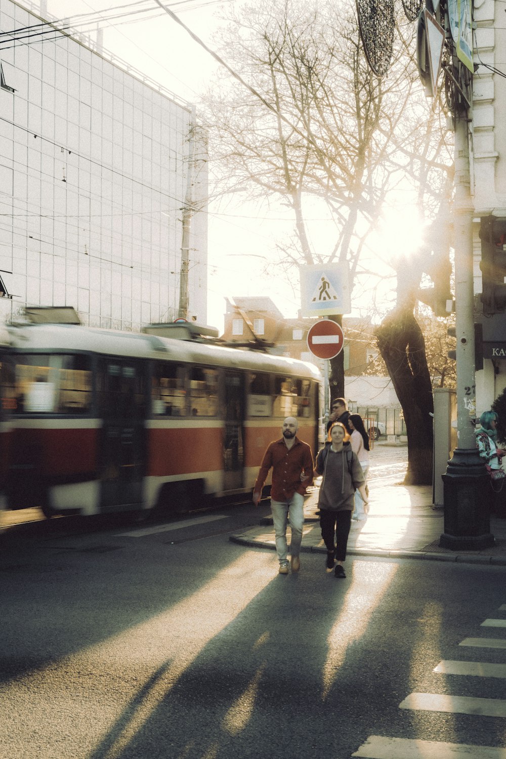 a group of people walking down a street next to a bus