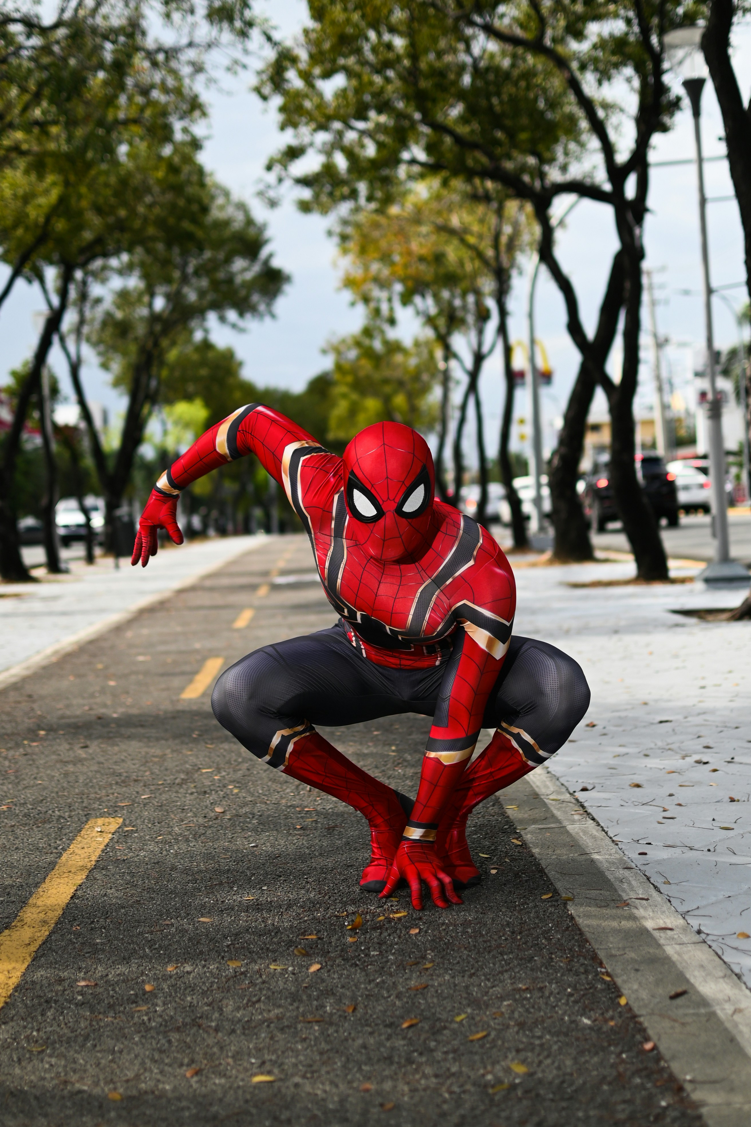 a man in a spiderman suit is kneeling down