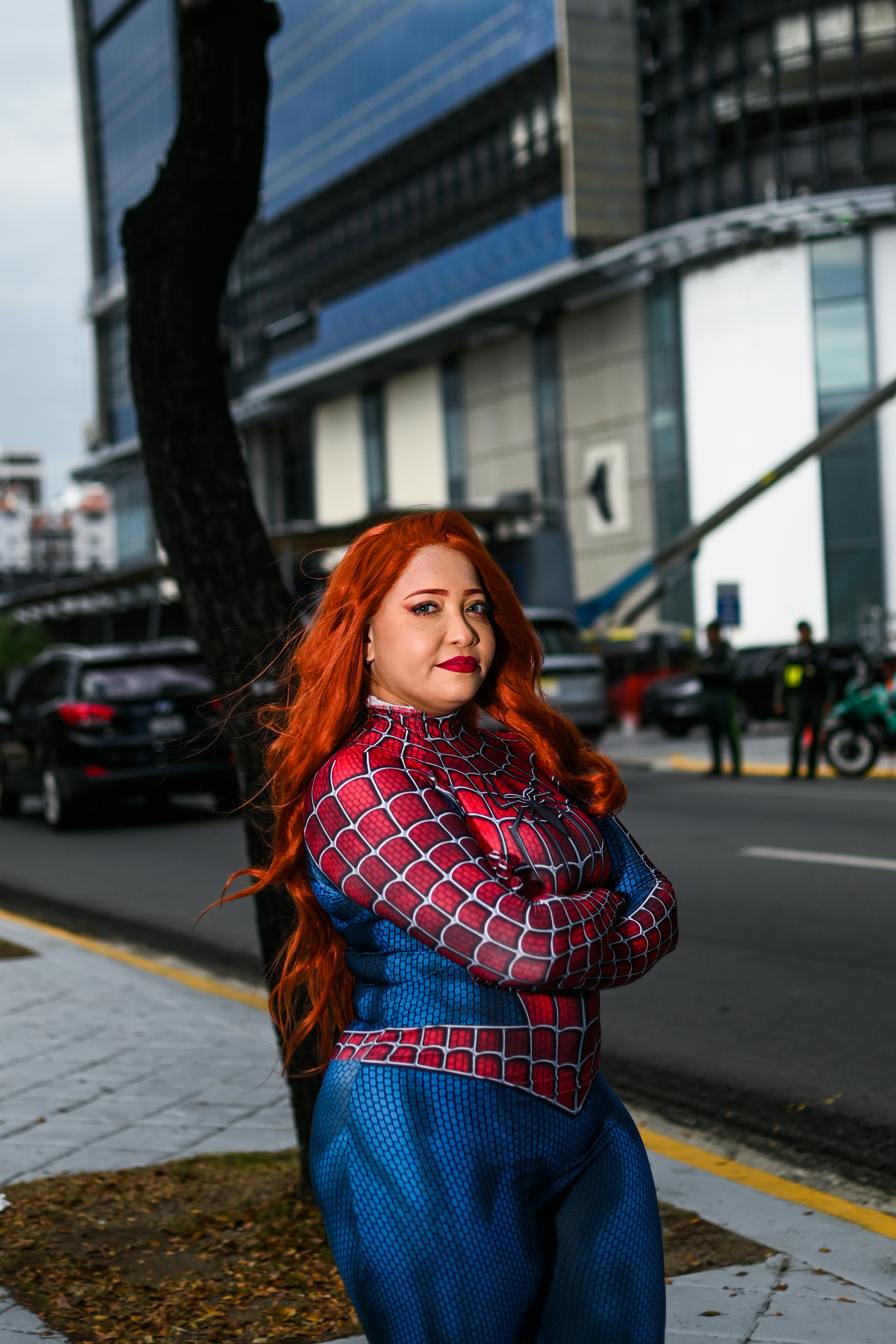 Seorang wanita berambut merah berdiri di trotoar