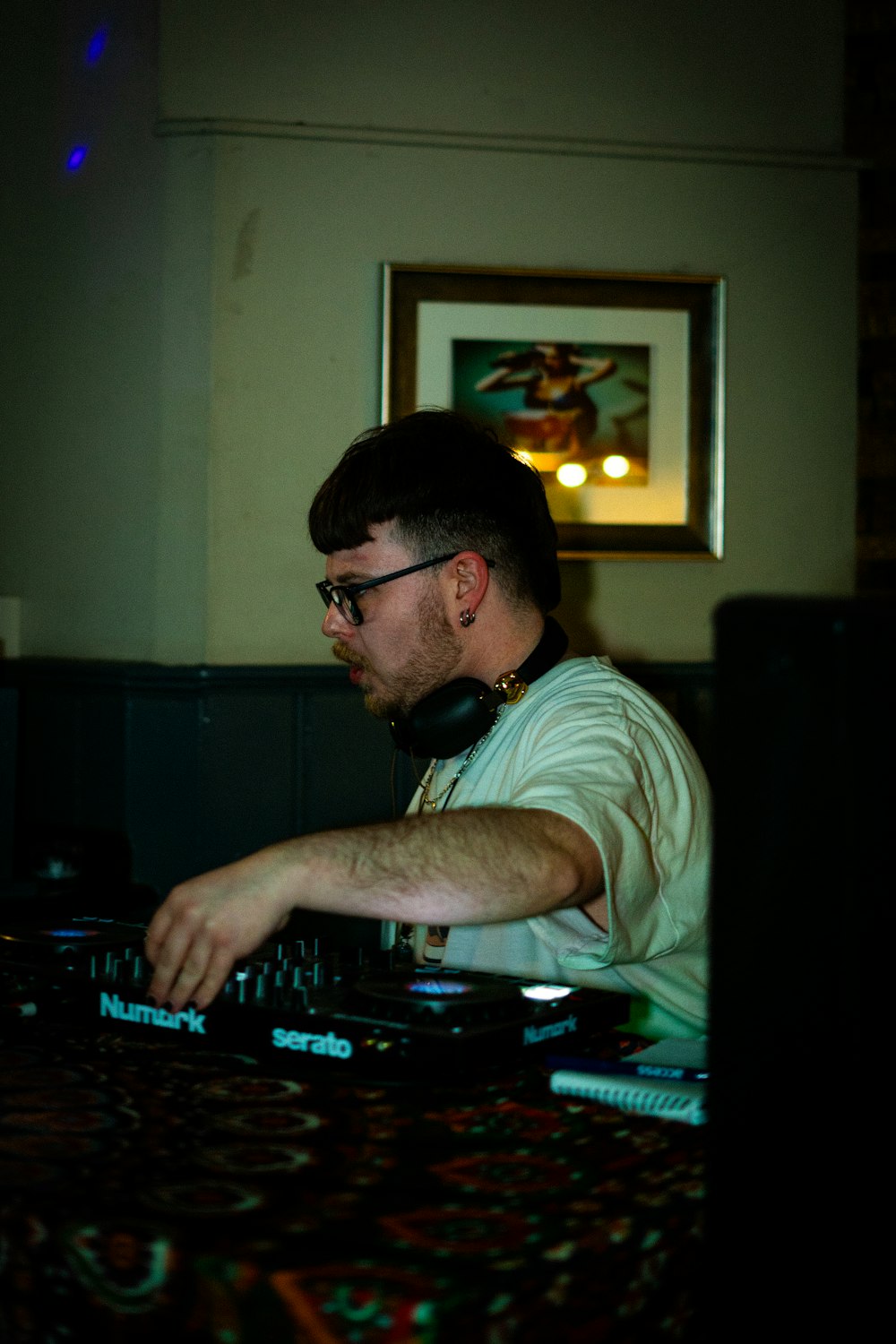 a man sitting at a table with a dj controller