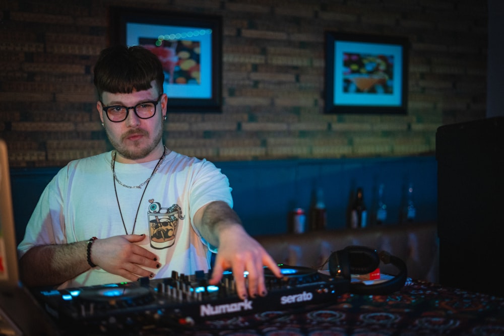 a man in a white t - shirt is mixing music