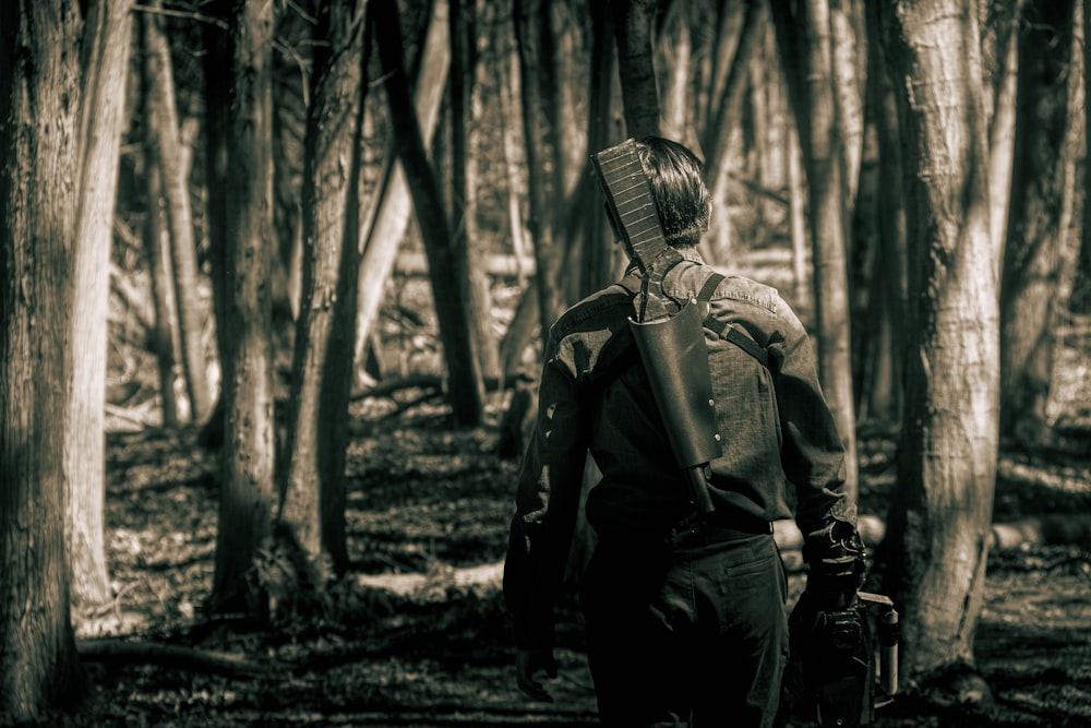 a man with a backpack walking through a forest