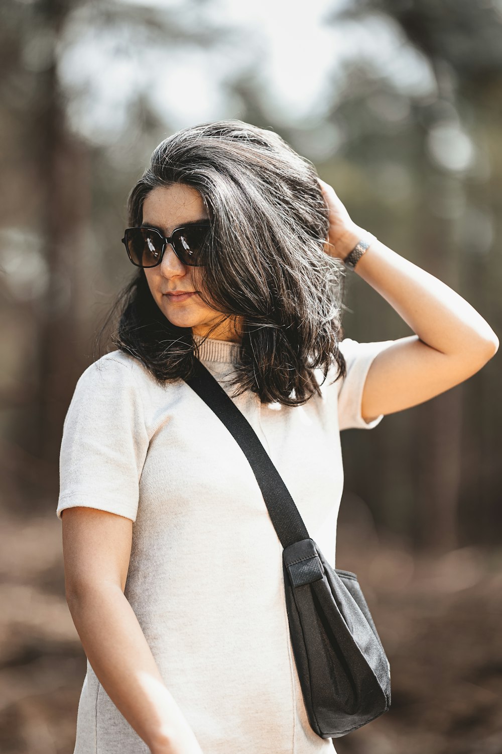 a woman wearing sunglasses and a white shirt