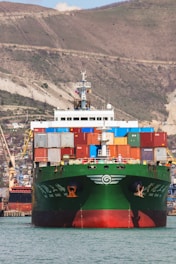 a large green and red ship in the water