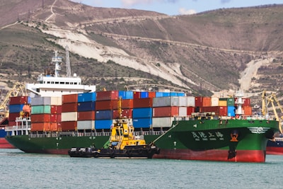 a large cargo ship in the water with a mountain in the background