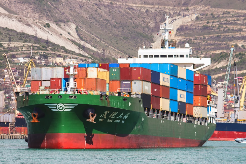 a large green and red ship in the water