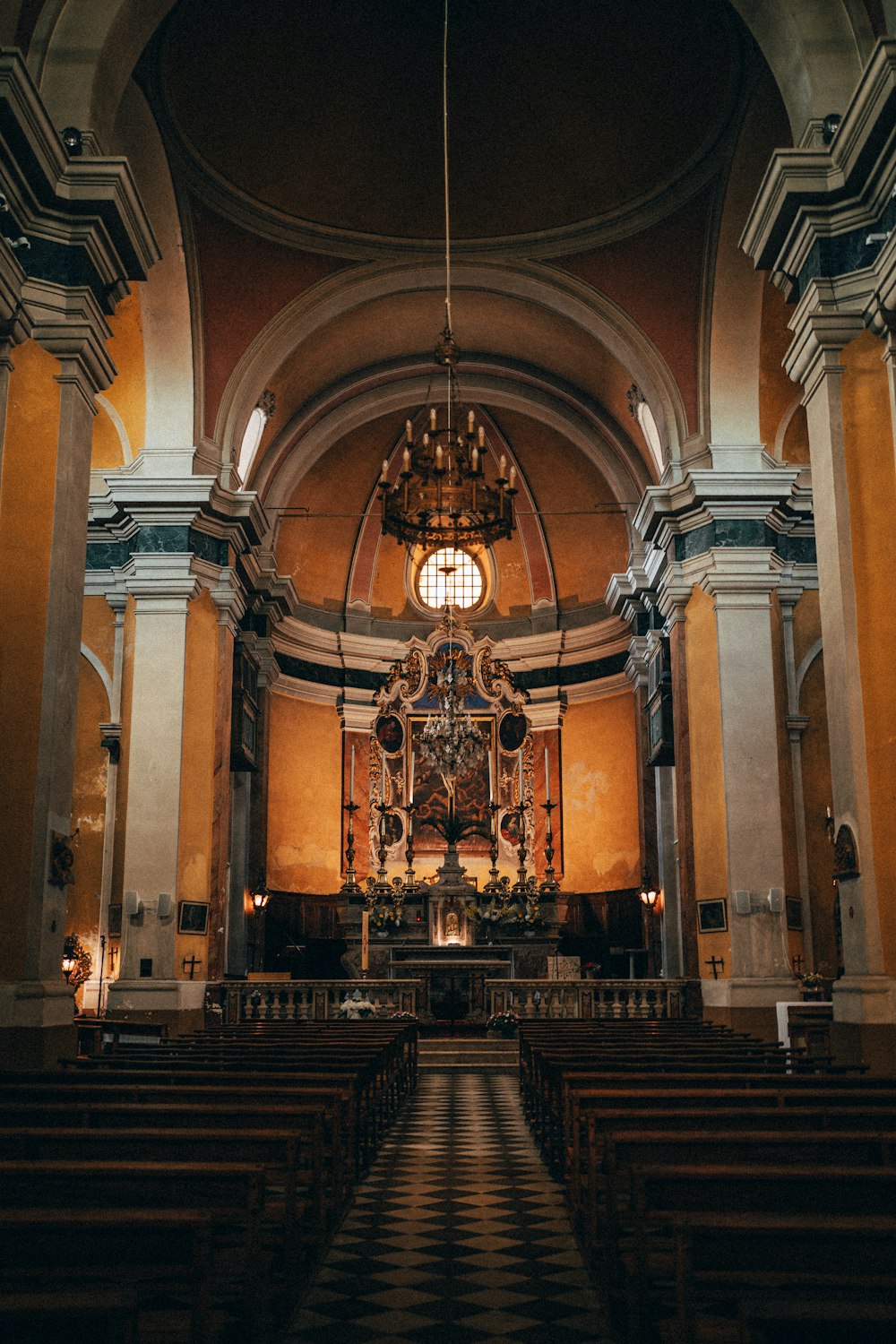 the inside of a church with pews and a chandelier